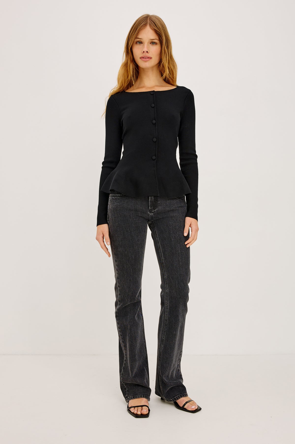 Diane Top in Fine Gauge Knit With Peplum Hem, Boat Neckline, and Decorative Self-Covered Front Center Buttons in Black Colorway - Full Body Front View Featured on Model
