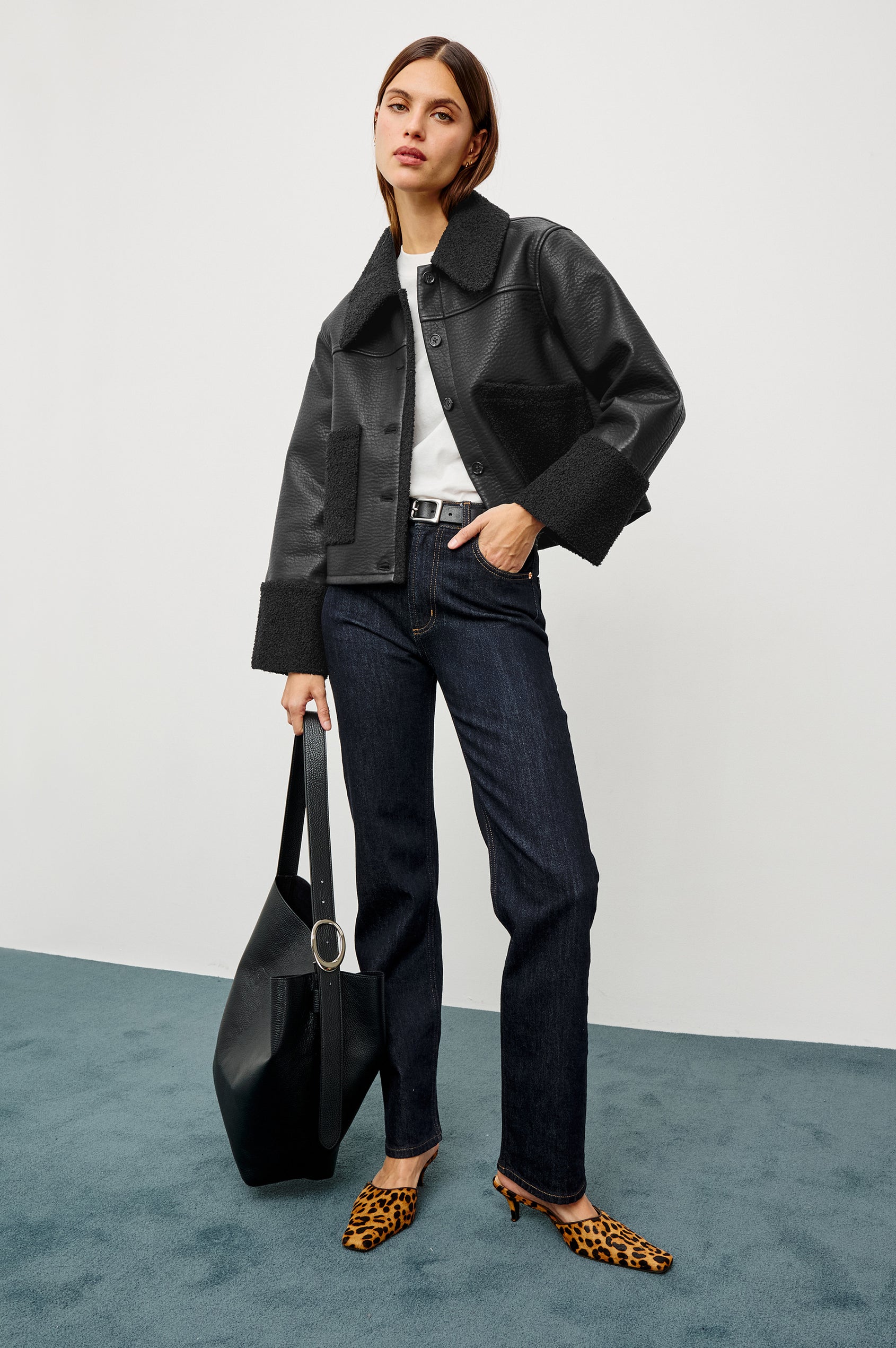 Dria Jacket in Vegan Leather With Cropped Boxy Fit, Faux Shearling Cuffs, Collar, and Patch Pockets, Faux Horn Logo Front Buttons, and Long Sleeves in Black Shearling Colorway - Full Body Featured on Model