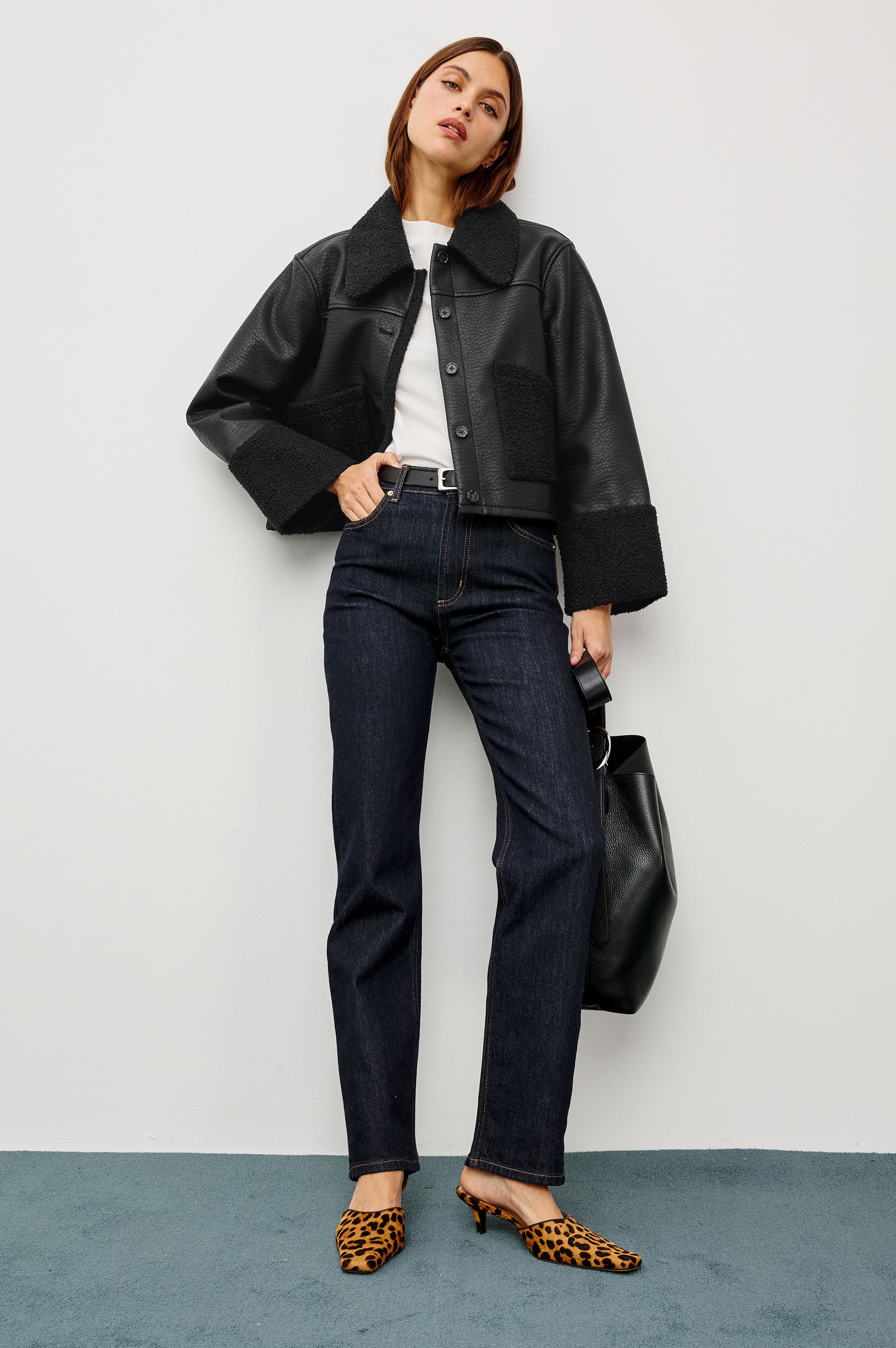 Dria Jacket in Vegan Leather With Cropped Boxy Fit, Faux Shearling Cuffs, Collar, and Patch Pockets, Faux Horn Logo Front Buttons, and Long Sleeves in Black Shearling Colorway - Full Body Featured on Model