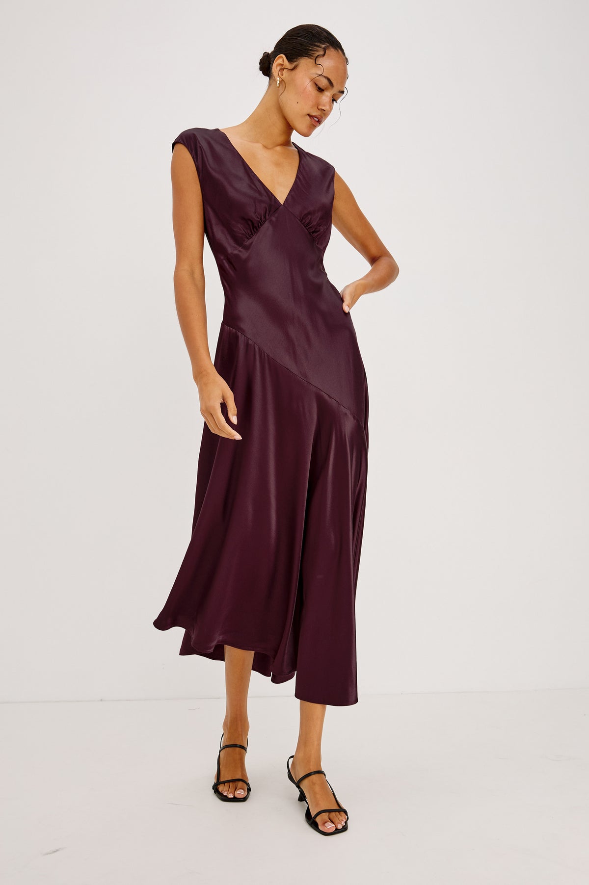 Eleni Midi Dress in Satin-Back Crepe With V-Neckline, Side Zip, Asymmetric Seam, and Handkerchief Hem in Wine Colorway - Front Full Body View Featured on Model.