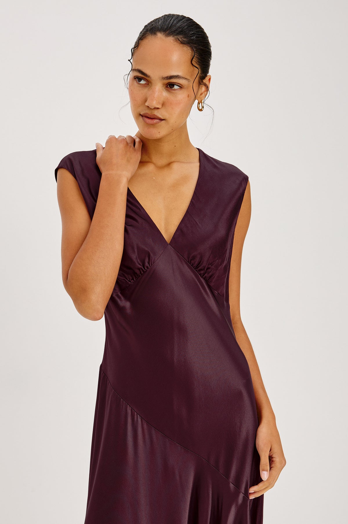 Eleni Midi Dress in Satin-Back Crepe With V-Neckline, Side Zip, Asymmetric Seam, and Handkerchief Hem in Wine Colorway - Front Full Body View Featured on Model.