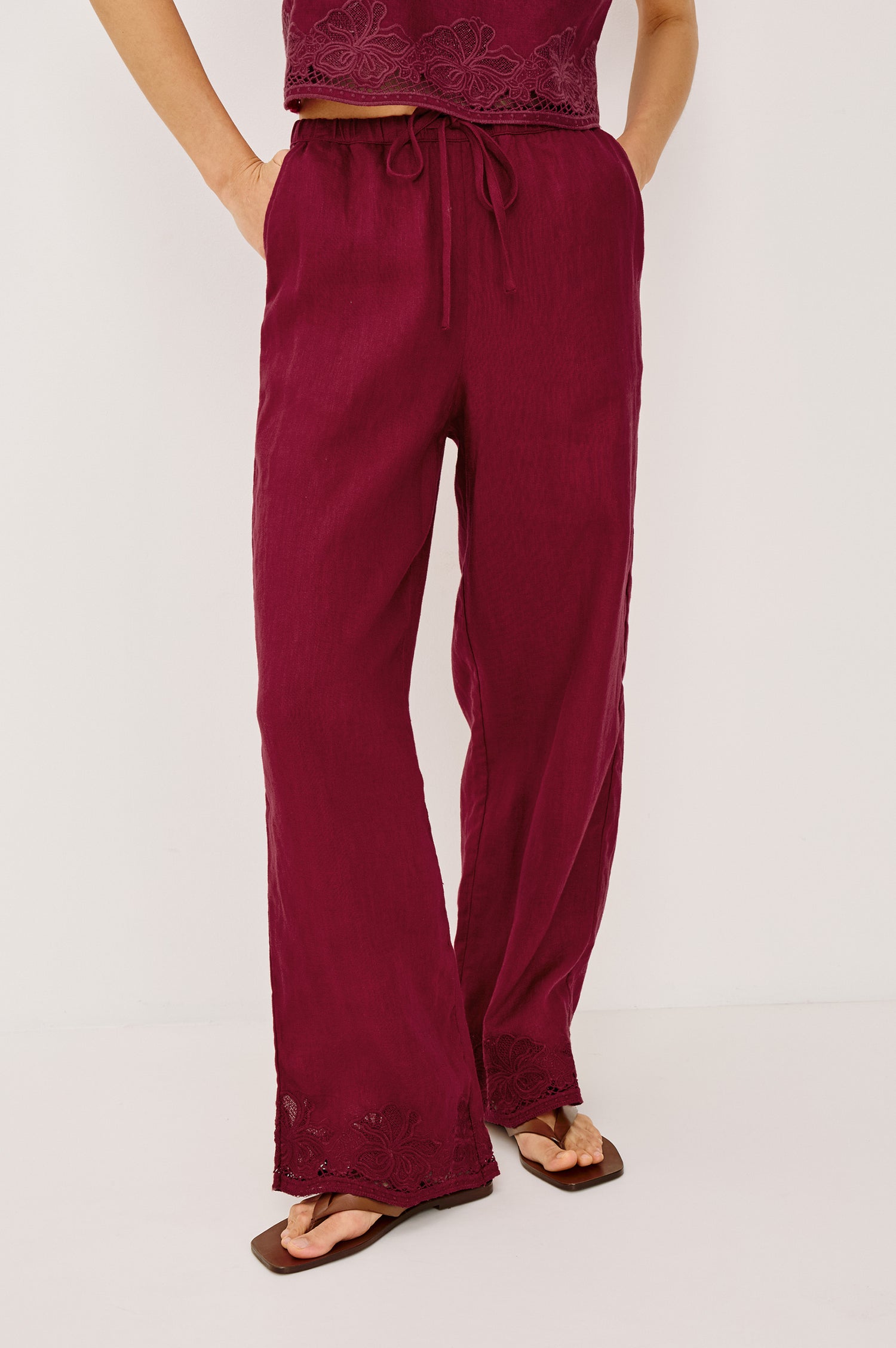 Emmie Straight Leg Pant in Linen With Adjustable Drawstring Waist Ties in Hibiscus Embroidery Colorway — Lower Body Front View Featured on Model
