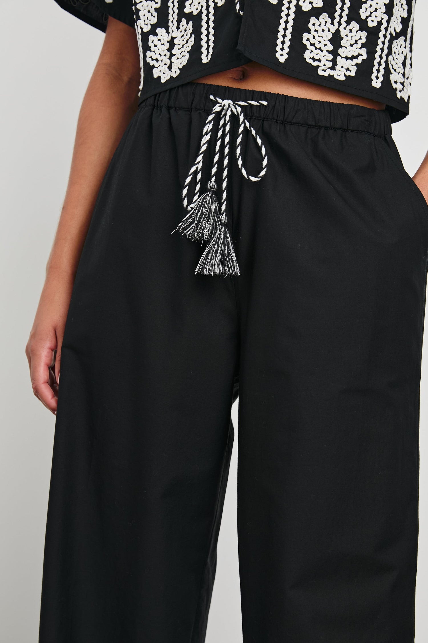 Emmie Pants with a Drawstring Waist and Two Front Pockets in Black Ivory Palm Trees Colorway, with white palm trees at the cuffs  - Front View Featured on Model