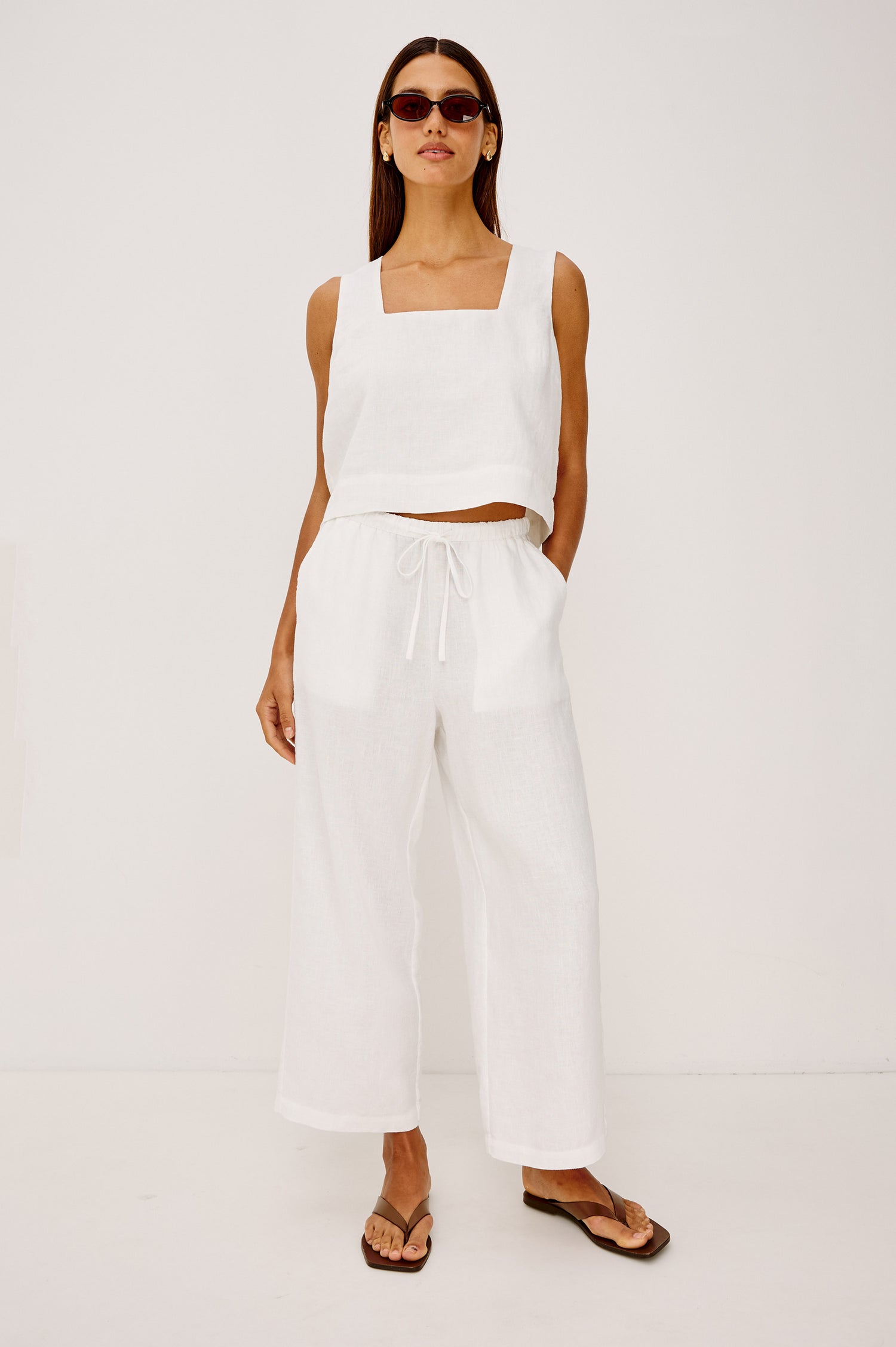 Emmie Crop Pant in Linen With Straight Legs, Adjustable Drawstring Waist Ties, and Side Pockets in White Linen Colorway - Full Body Front View Featured on Model