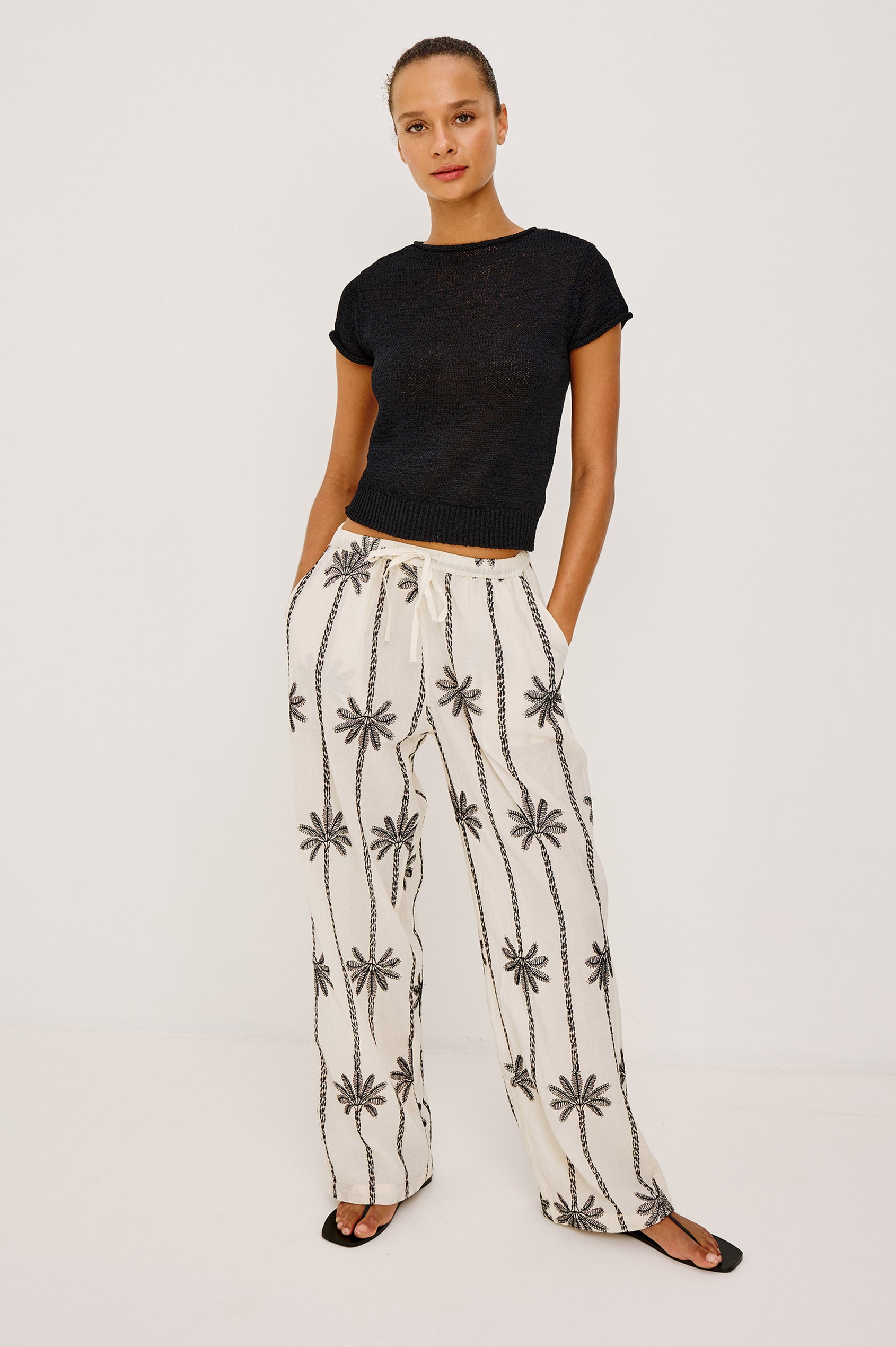Emmie Straight Leg Pant in Unlined Linen With Adjustable Drawstring Waist Ties and Side Pockets in Emerald Palms Embroidery Colorway — Lower Body Front View Featured on Model