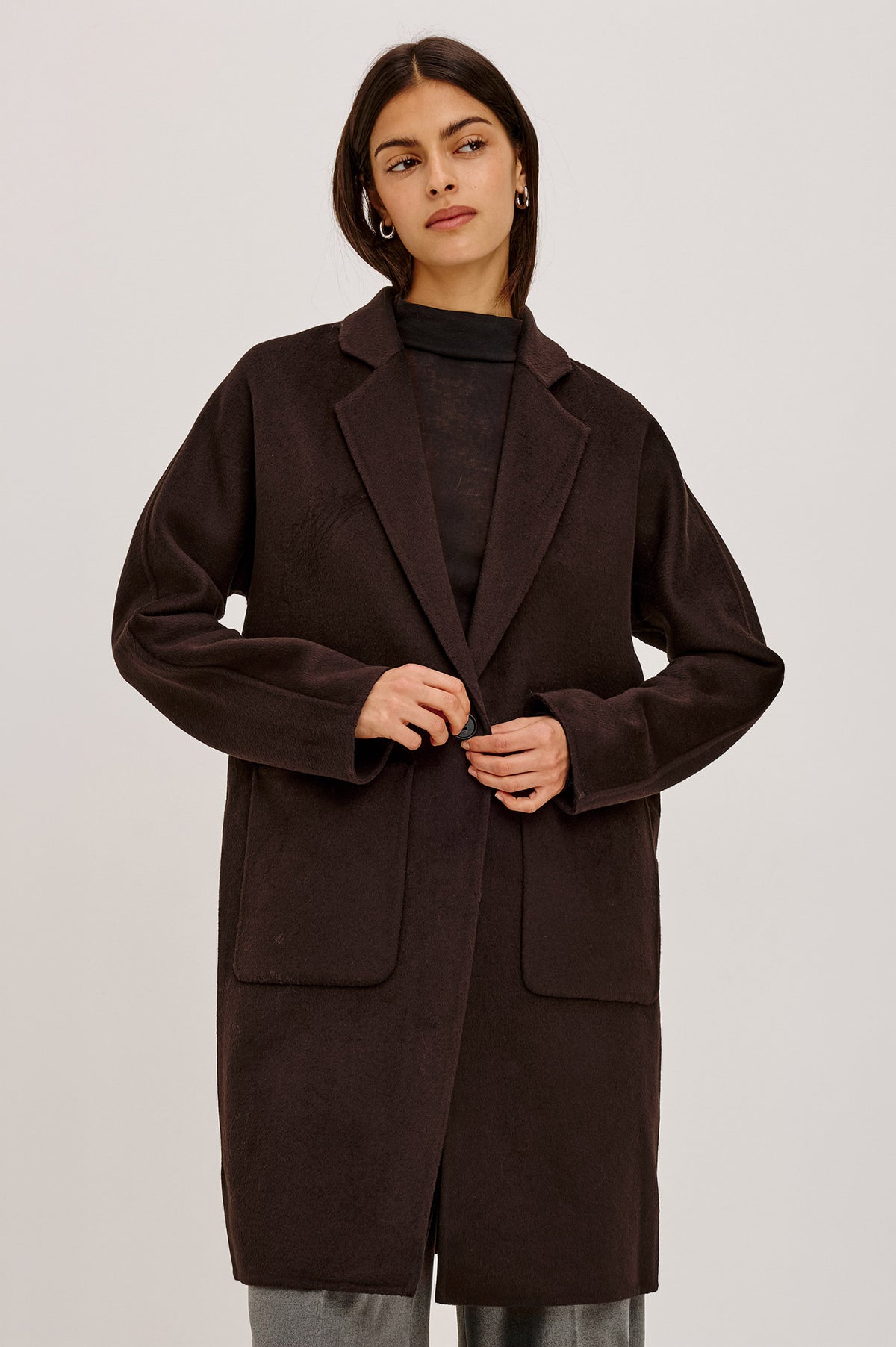 Everest Coat in Heavy Wool Blend With Longline Cut, Slightly Oversized Relaxed Fit, Lapel Collar, Single-Button Front, and Front Patch Pockets in Chocolate Colorway - Front View Featured on Model.