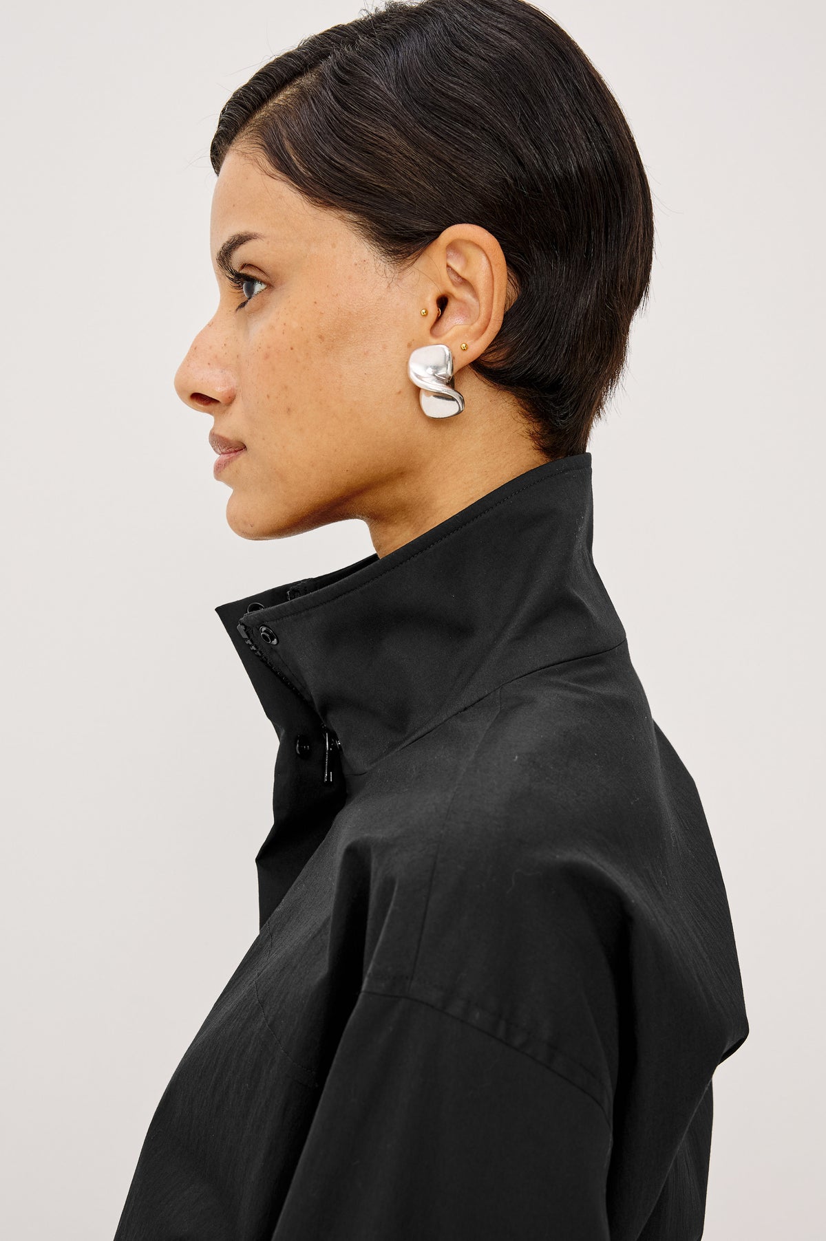 Felix Jacket in Cotton Nylon With Snap-Button Stand Collar, Front Zip-and-Snap Closures, Elastic Cuffs, Long Sleeves, and Drawcord Sides in Black Colorway - Upper Body Side View Featured on Model