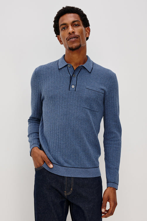 Fenton long sleeve polo sweater with a chest pocket, 3-button placket and collar with dark blue tipping along seam edges in Blue Melange Colorway. Front view of model shown.
