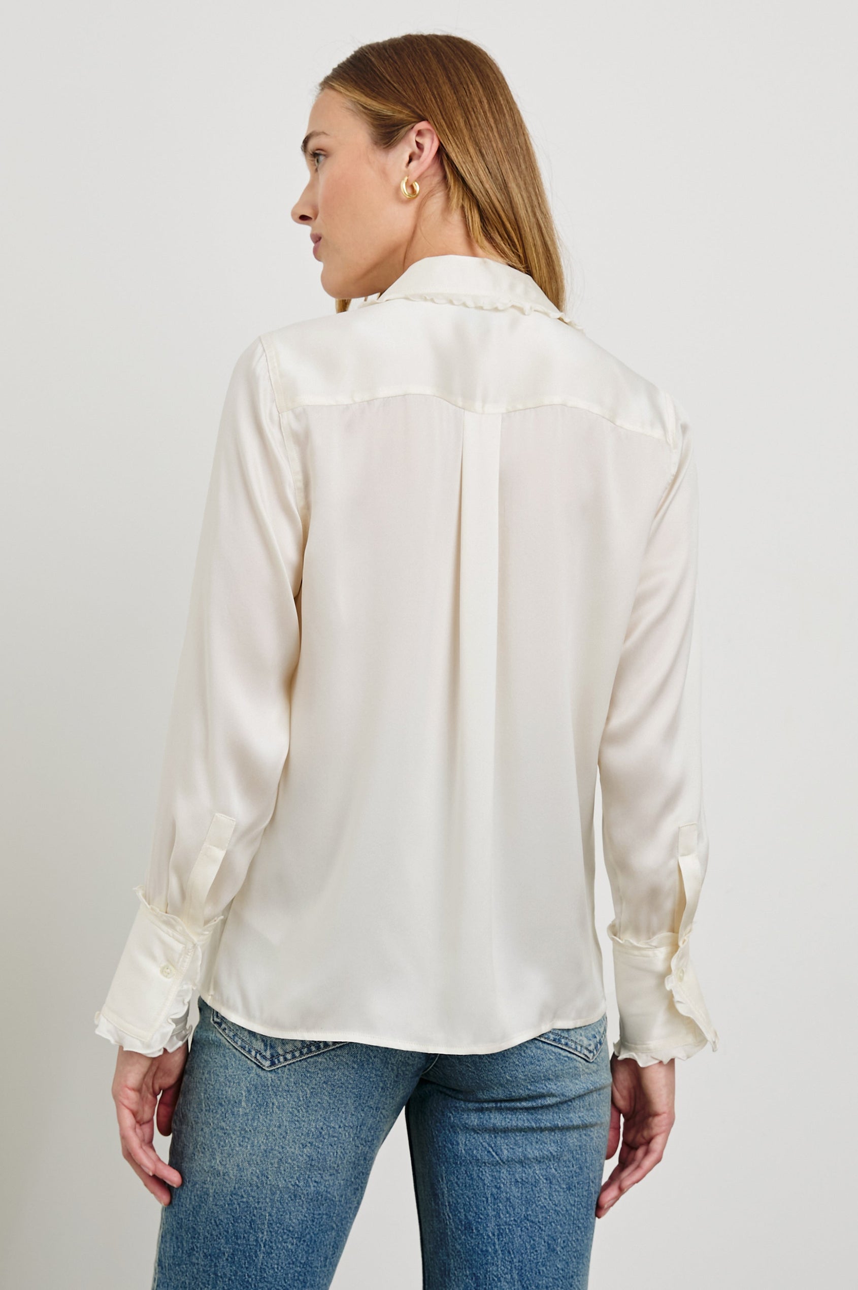 Fia Long-Sleeve Button Up with Lettuce Edges on the Collar, Cuffs, and Closure in Ivory Colorway - Back View Featured on Model 