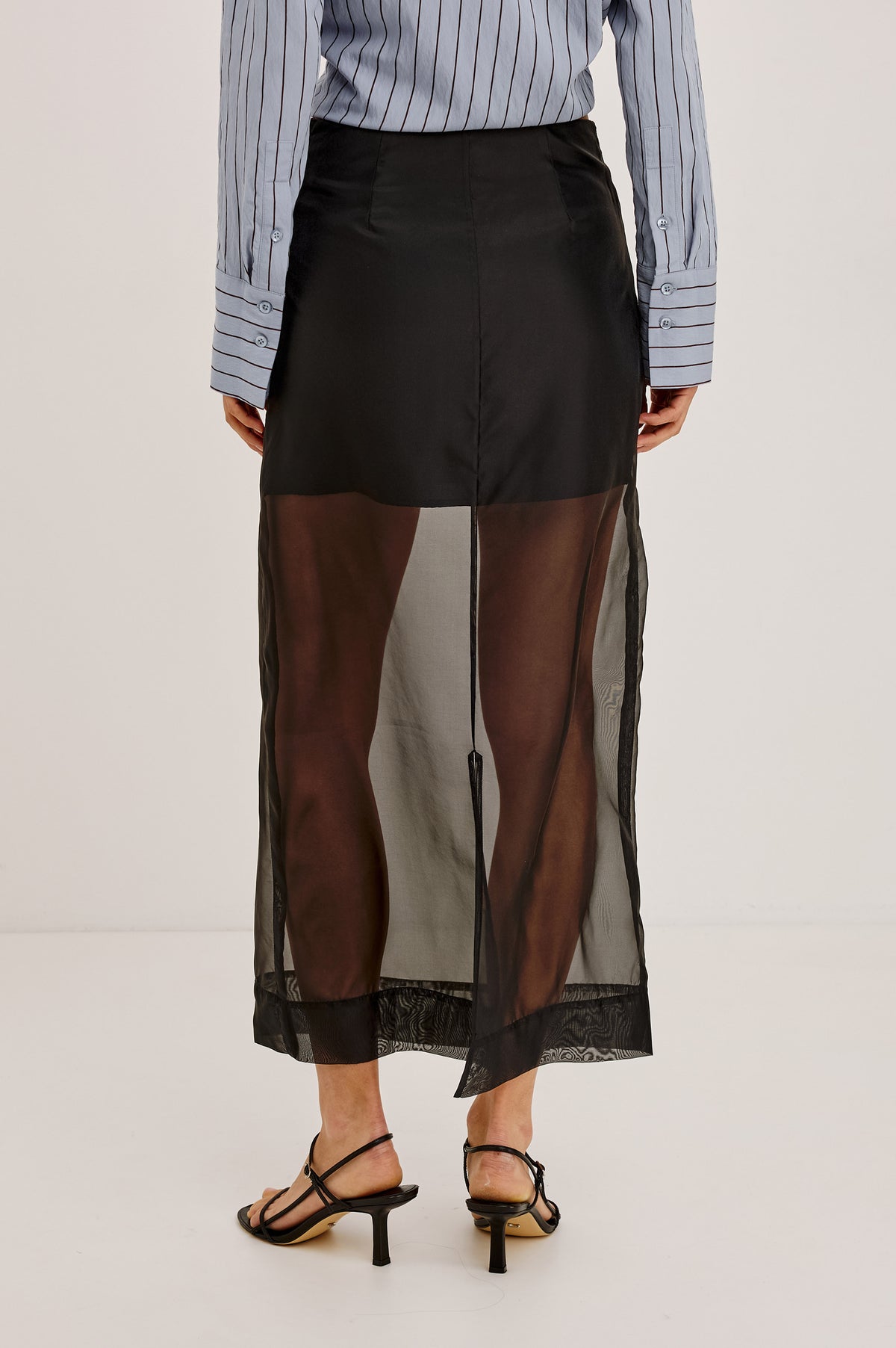 Floran Midi Skirt in Sheer Organza With Mini Lining, Side Zip, Straight Hem, and Back Slit in Black Organza Colorway - Upper Body Back View Featured on Model.