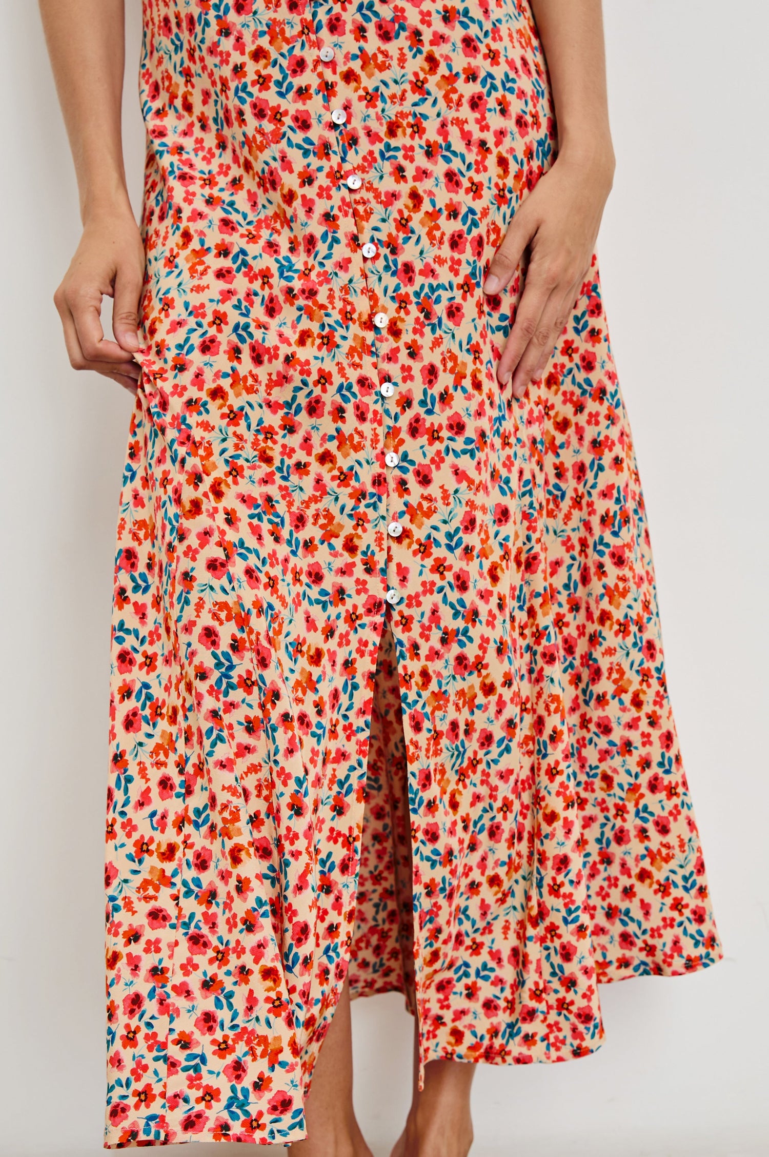 Florian Midi Dress with a V-Neckline, Spaghetti Straps, and Buttons down the front in Red Posy Colorway, Red, Blue and Orange on Tan - Front View Featured on model