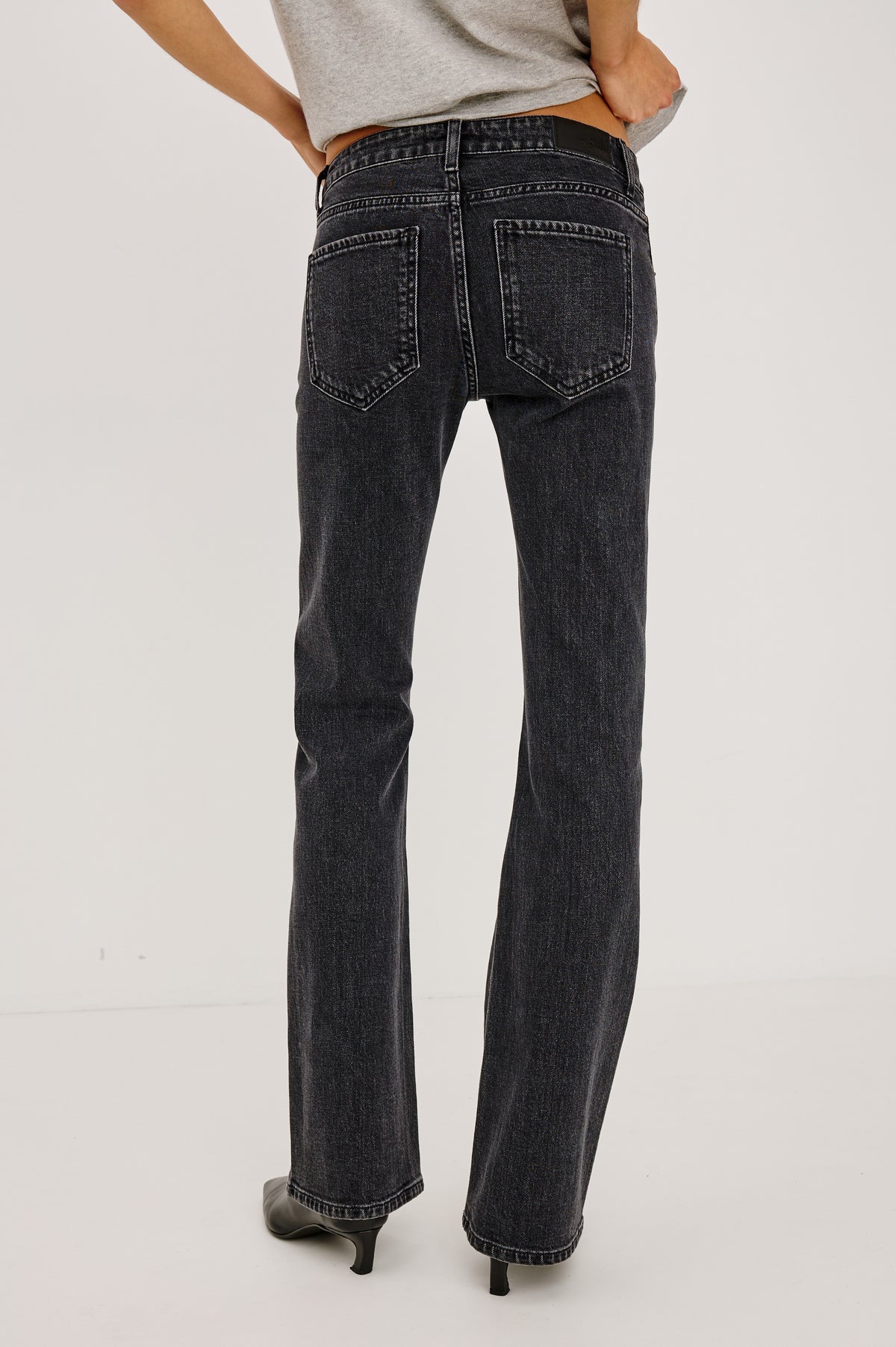 Fremont Petite Low Rise Bootcut Jean in Light Stretch Denim With Extended Inseam, 5-Pockets, Distressed Details, Belt Loops, and Zip-Fly Closure in Blackjack Colorway - Lower Body Back View Featured on Model