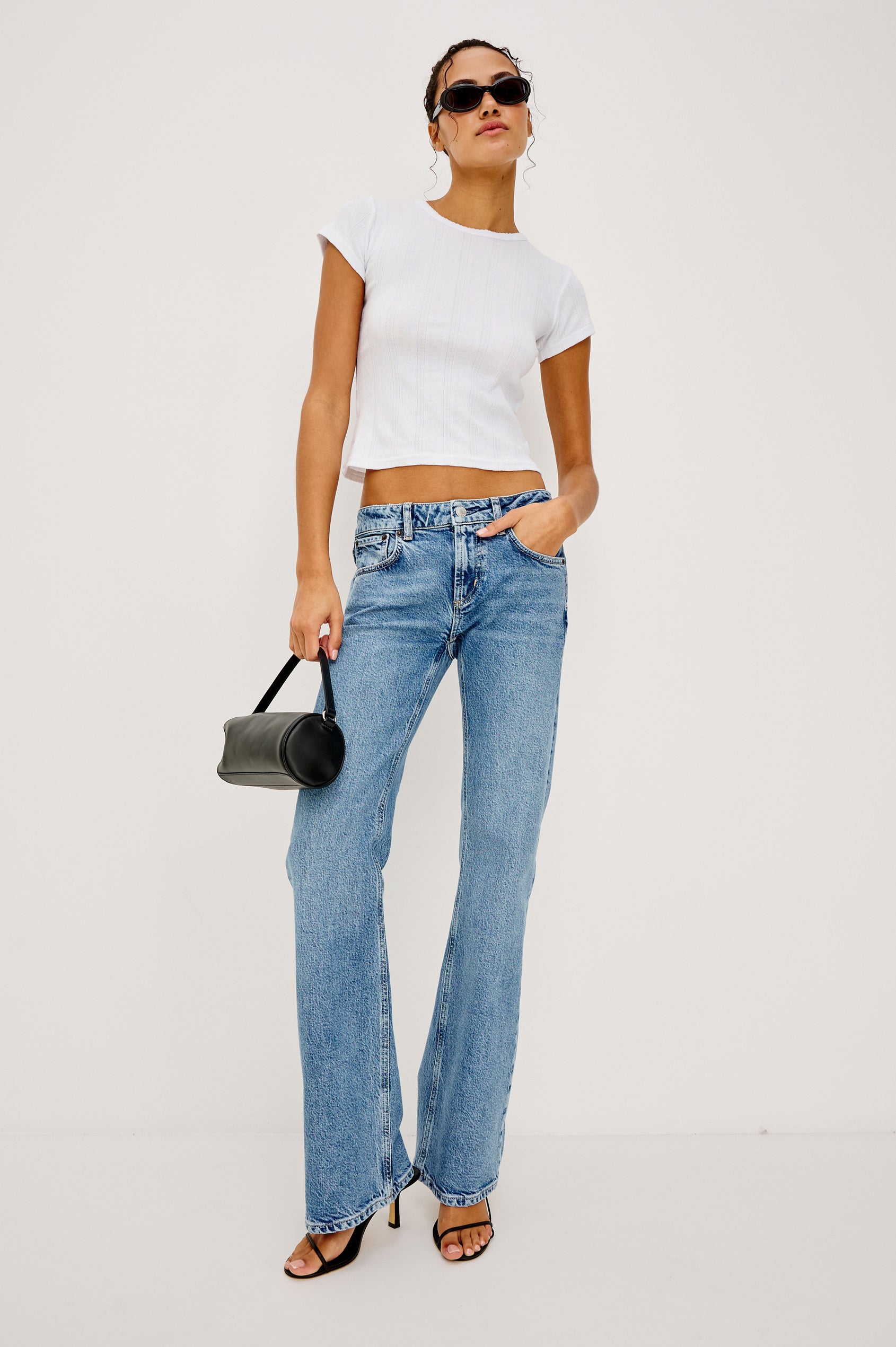Fremont Petite Low Rise Bootcut Jean in Light Stretch Denim With Extended Inseam, 5-Pockets, Distressed Details, Belt Loops, and Zip-Fly Closure in Old Indigo Colorway - Full Body Front View Featured on Model