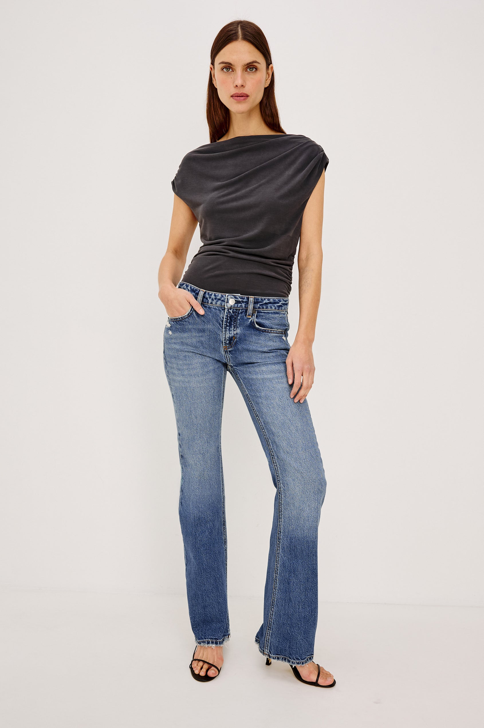 Fremont Low Rise Bootcut Jean in Light Stretch Denim With Extended Inseam, 5-Pockets, Distressed Details, Belt Loops, and Zip-Fly Closure in Pioneertown Colorway - Full Body Front View Featured on Model