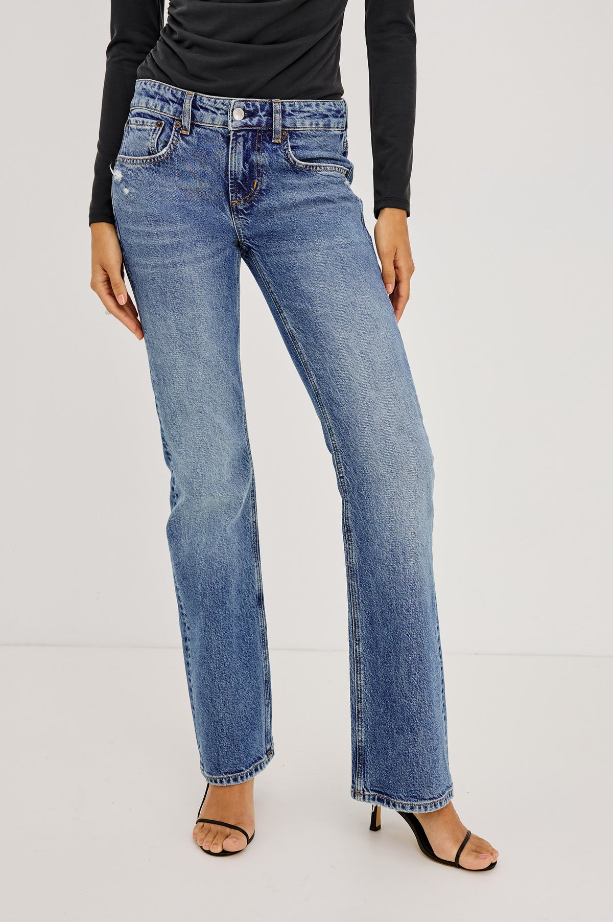 Fremont Low Rise Bootcut Jean in Light Stretch Denim With Extended Inseam, 5-Pockets, Distressed Details, Belt Loops, and Zip-Fly Closure in Pioneertown Colorway - Lower Body Front View Featured on Model