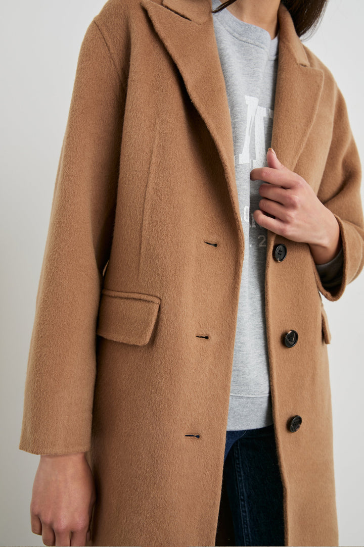 Gallery Below-the-Knee Coat with Three-Button Closure, Notched Lapels, and Two Front Flap Pockets in Camel Colorway - Front View Featured on Model