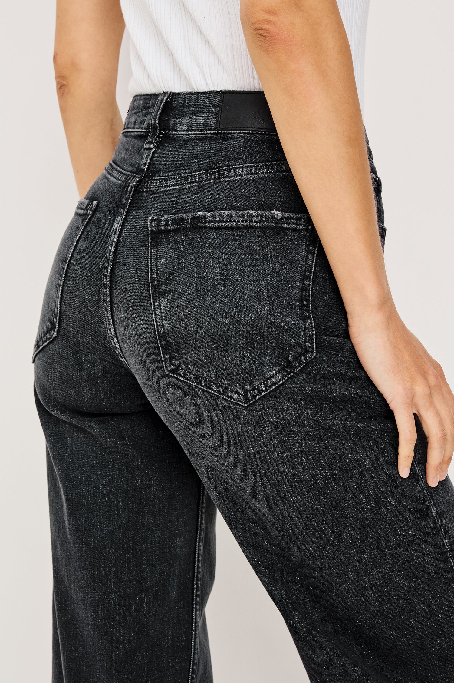 Getty Wide Leg Jean in Dark Wash Denim With High-Rise High-Waisted Fit, Front Button Fly, 5-Pocket Styling in Black Pearl Colorway - Lower Body Back Close Up View Featured on Model
