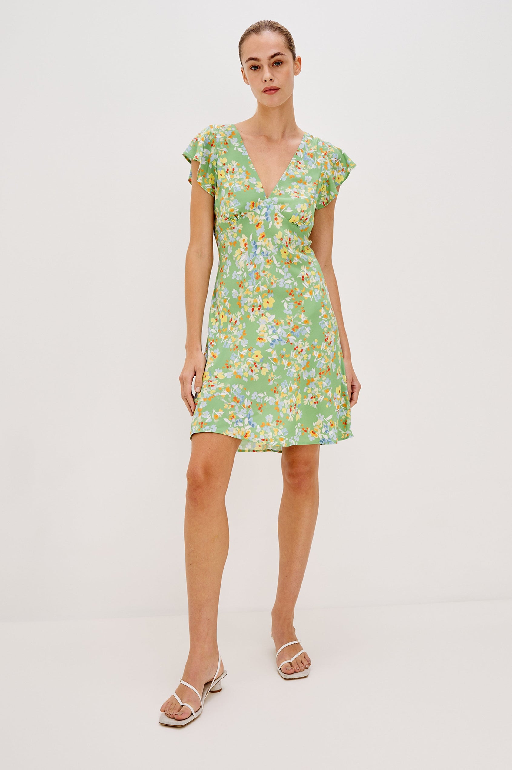 Gigi V-Neck Mini Dress with Short Flutter Sleeves, Empire Waist  in Green Meadow Colorway. Full Body Front View Shown on Model.