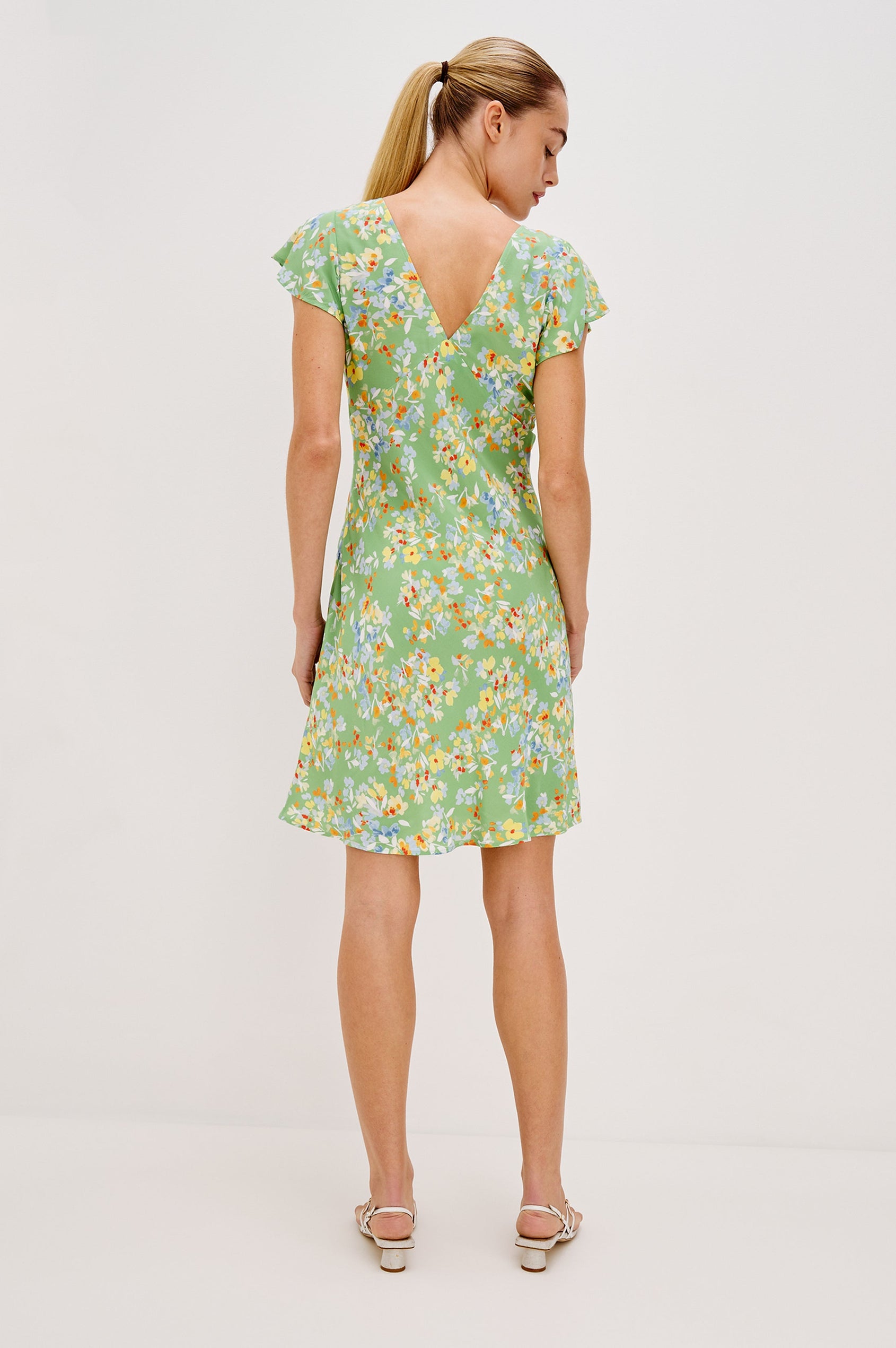Gigi V-Neck Mini Dress with Short Flutter Sleeves, Empire Waist  in Green Meadow Colorway. Back View Shown on Model.