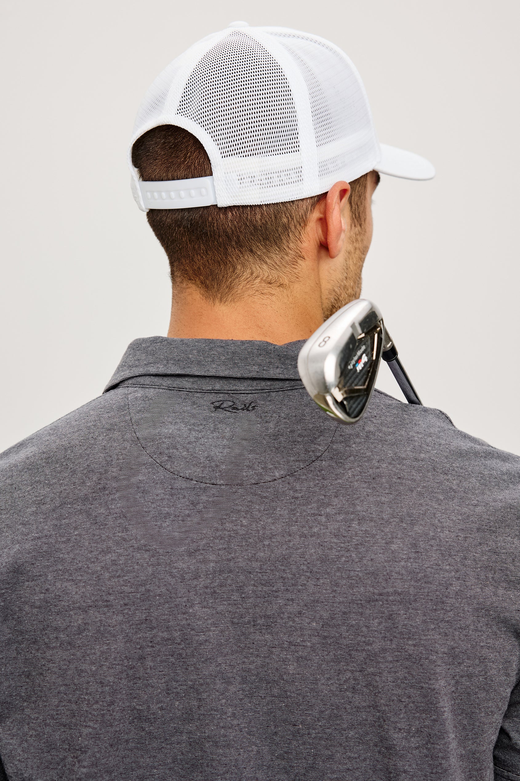 Golf Hat With Embroidered Branded Patch at Front, Adjustable Snapback, Mesh Back, and 6-Panel Construction in White Colorway - Upper Body Back View Featured on Model