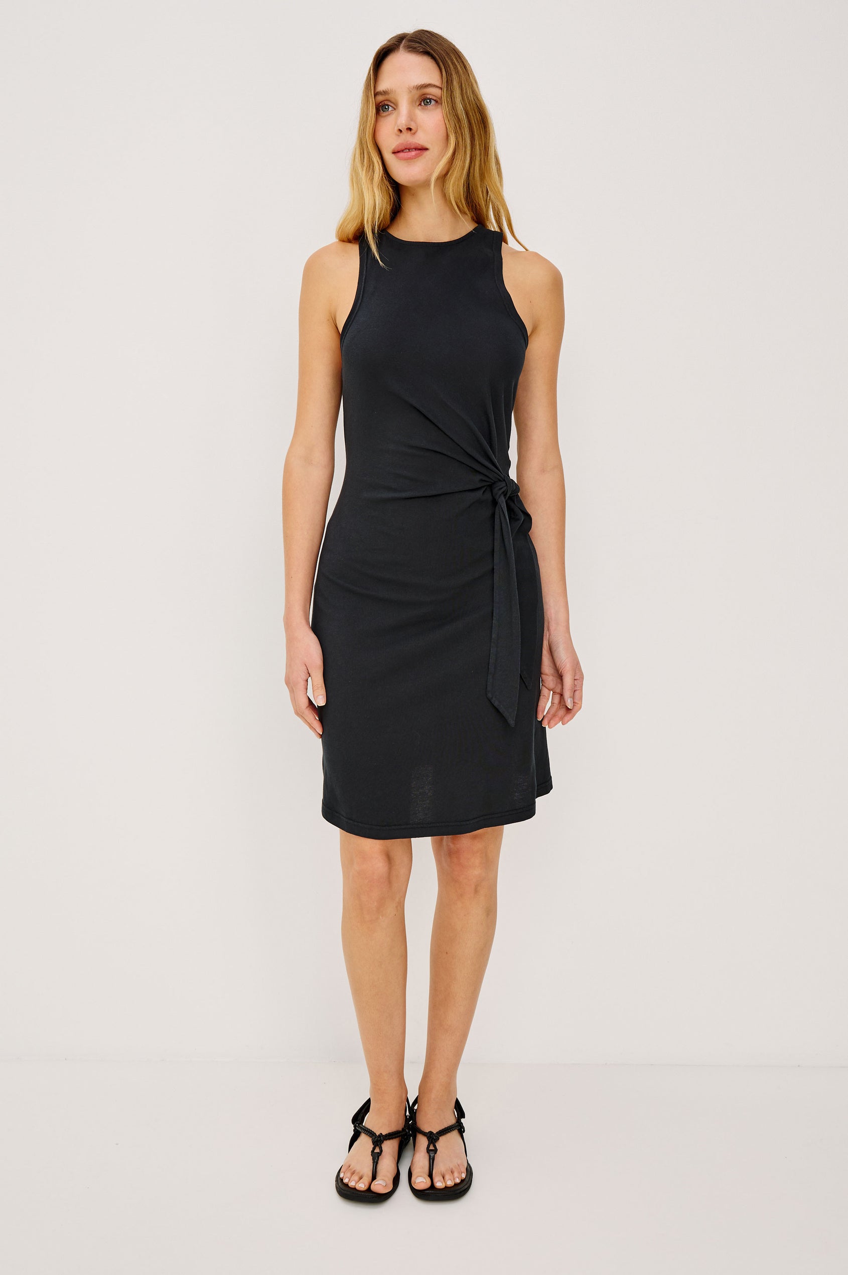Harriet Mini Dress in Cotton With HIgh Neckline, Waist Wrap Ties, and A-Line Skirt in Black Colorway - Full Body Front View Featured on Model