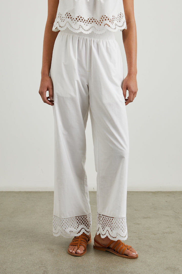 Henrik Pants with a Shirred Waist, Two Front Pockets and an Eyelet Design at the Hems in White Colorway - Front View Featured on Model 