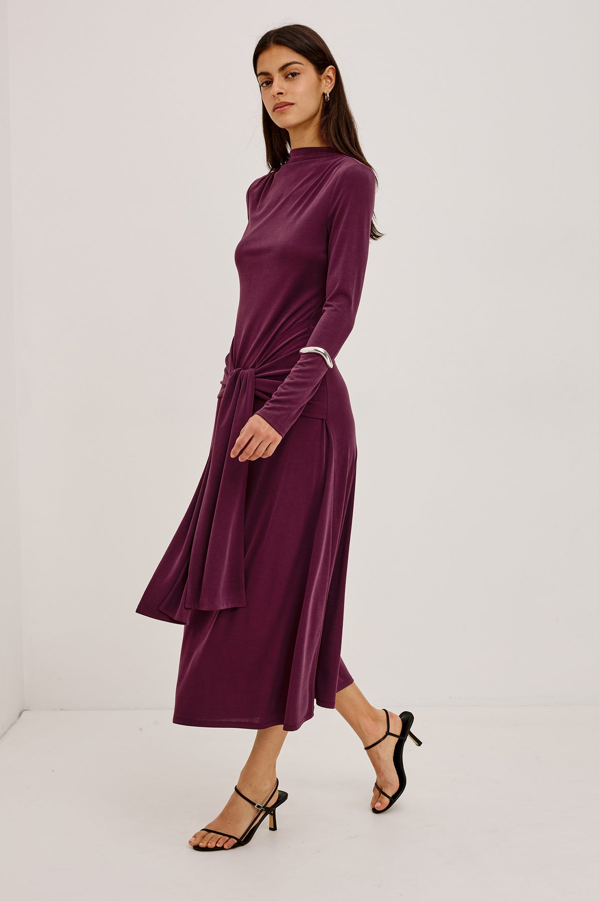 Hollis Midi Dress in Soft Jersey With Mockneck, Front Waist Ties, Pleated Shoulders, Long Sleeves, and A-Line Skirt in Wine Colorway - Upper Body Front View Featured on Model.