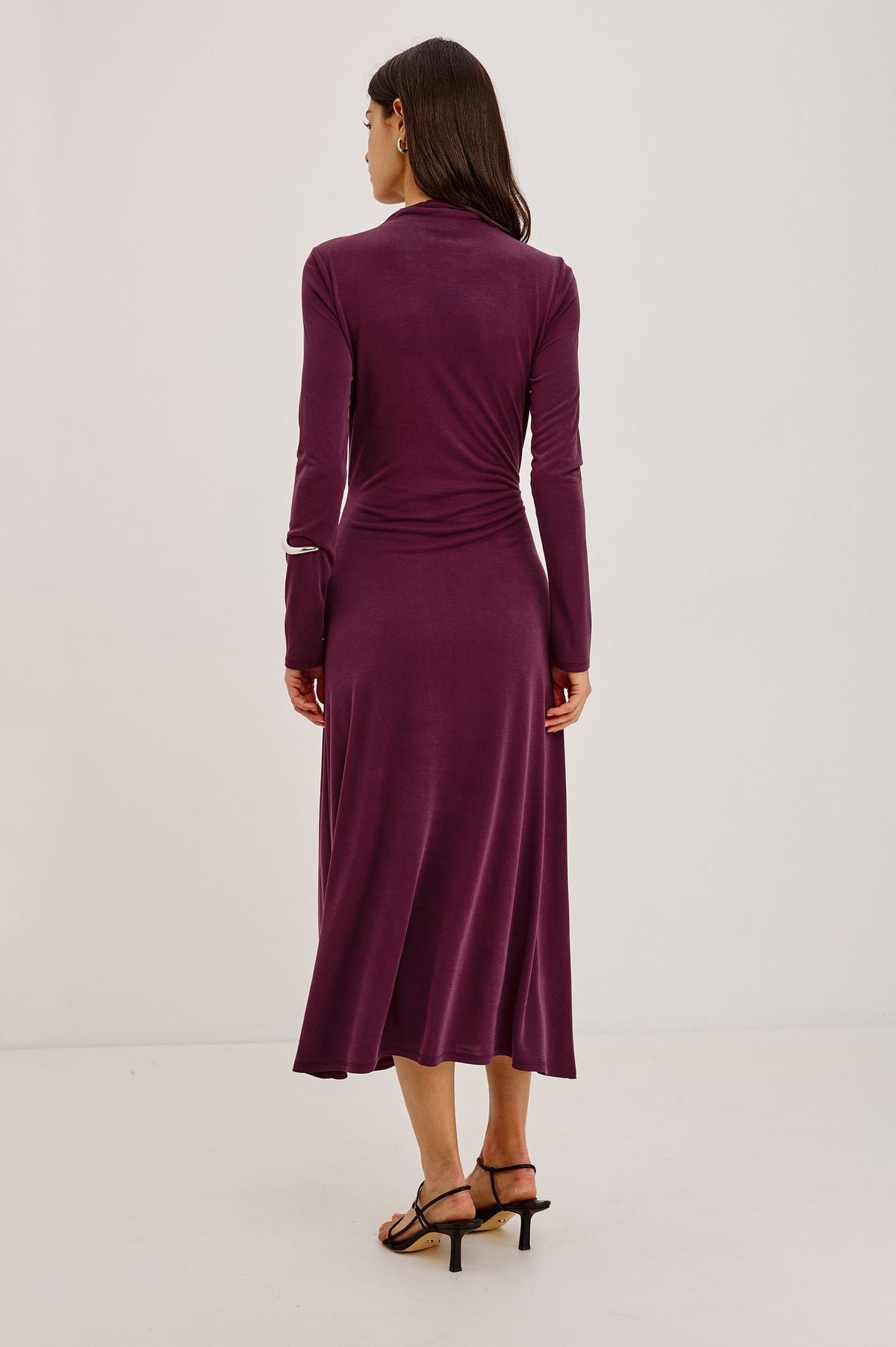Hollis Midi Dress in Soft Jersey With Mockneck, Front Waist Ties, Pleated Shoulders, Long Sleeves, and A-Line Skirt in Wine Colorway - Upper Body Back View Featured on Model.