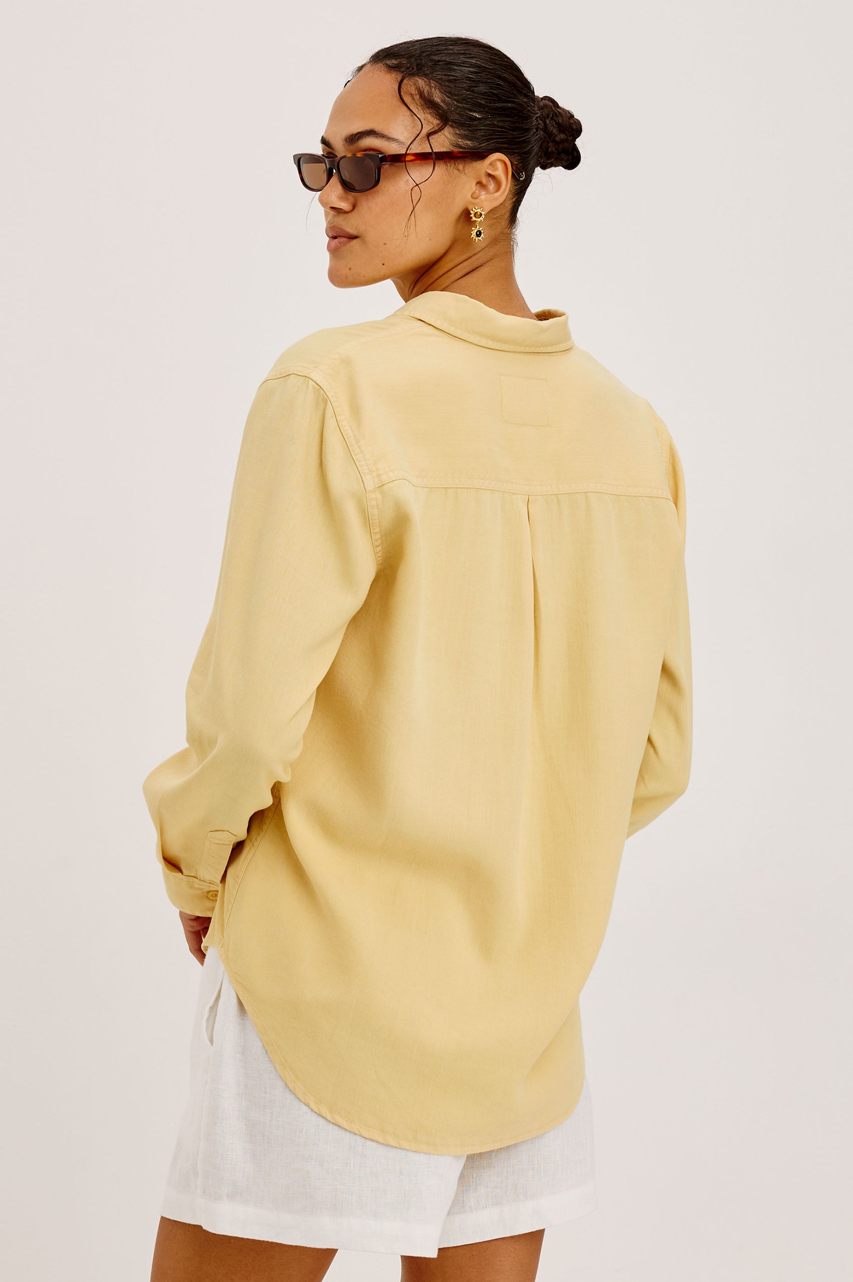 Ingrid Button-Up Shirt in TENCEL™Denim With Collar, Chest Patch Pocket, and Long Sleeves in Italian Straw Colorway - Upper Body Back View Featured on Model