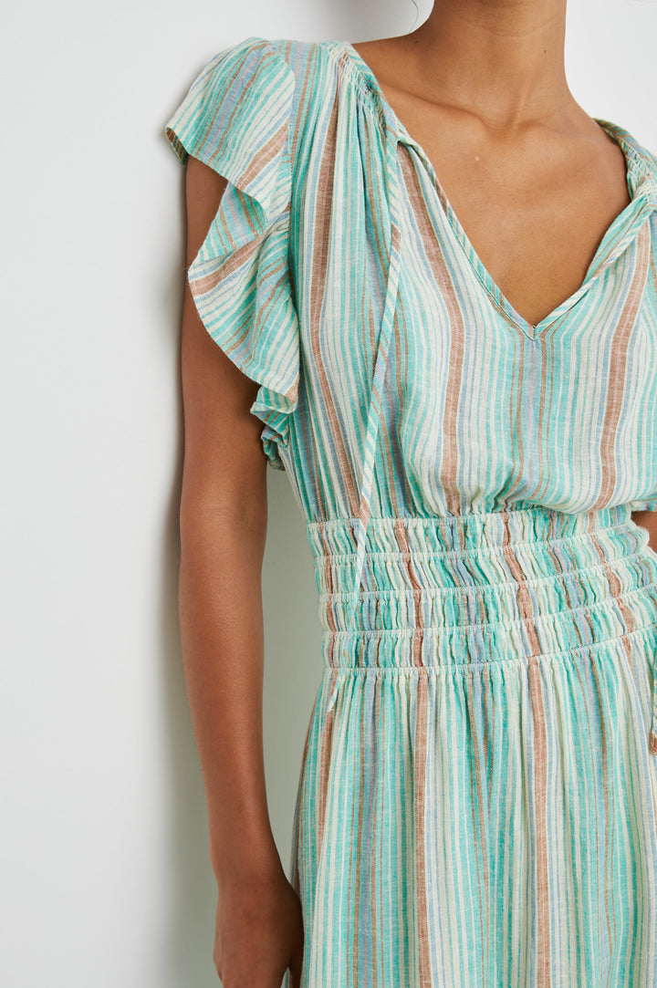 Iona Short Sleeve Midi Dress with Flutter Sleeves, a Deep V Neck with Ties, and a Shirred Waist in Seaview Stripe Colorway, Vertical Stripes in Browns, Blues and Creams - Front View Featured on Model 