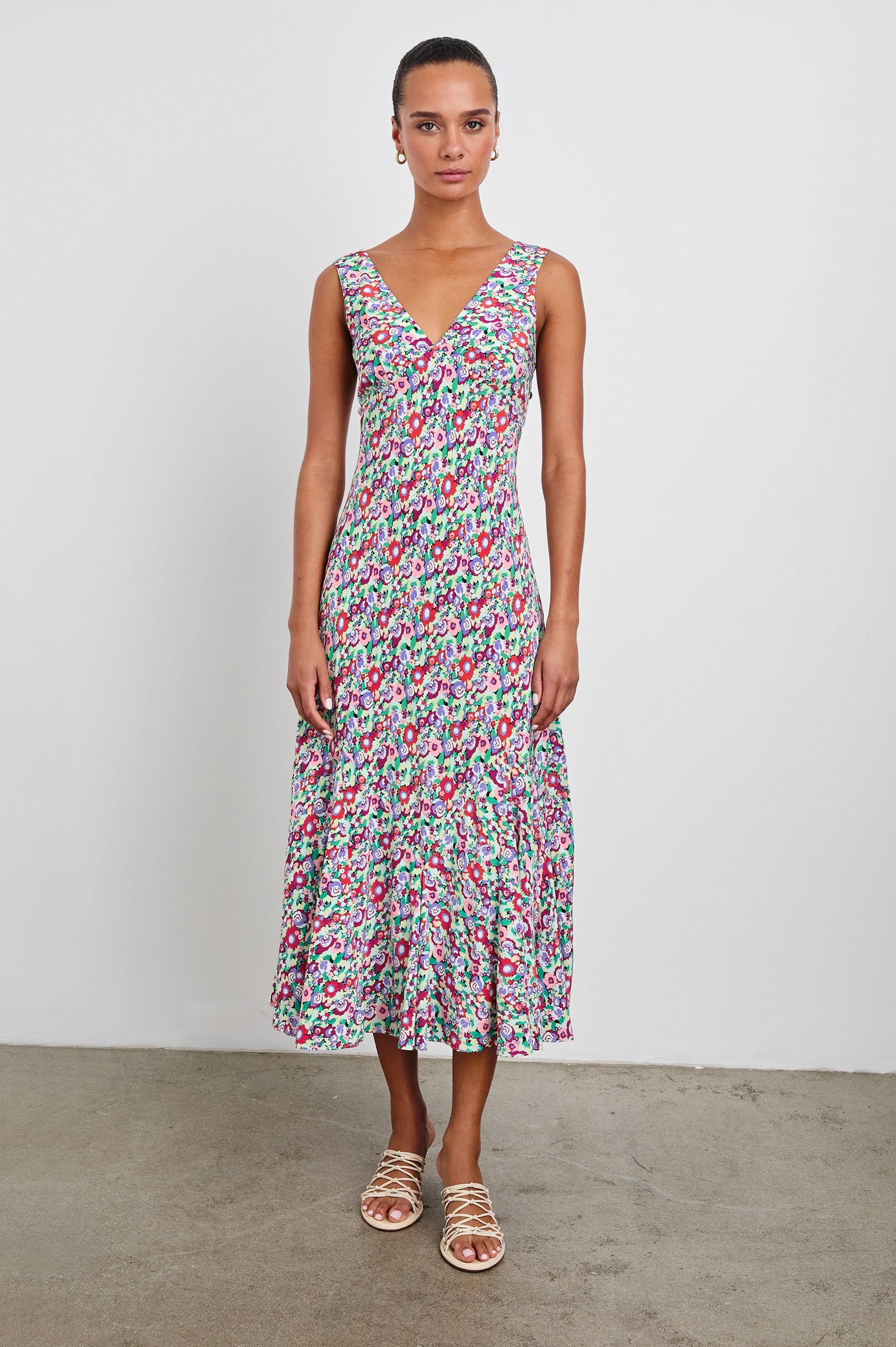 Irra Sleeveless Midi Dress with Wide Shoulder Straps, a Deep V Neck and an Empire Waist in Oversized Multi Floral Colorway, flowers in red, purple, pink and greens - Front Full Body View Featured on Model 