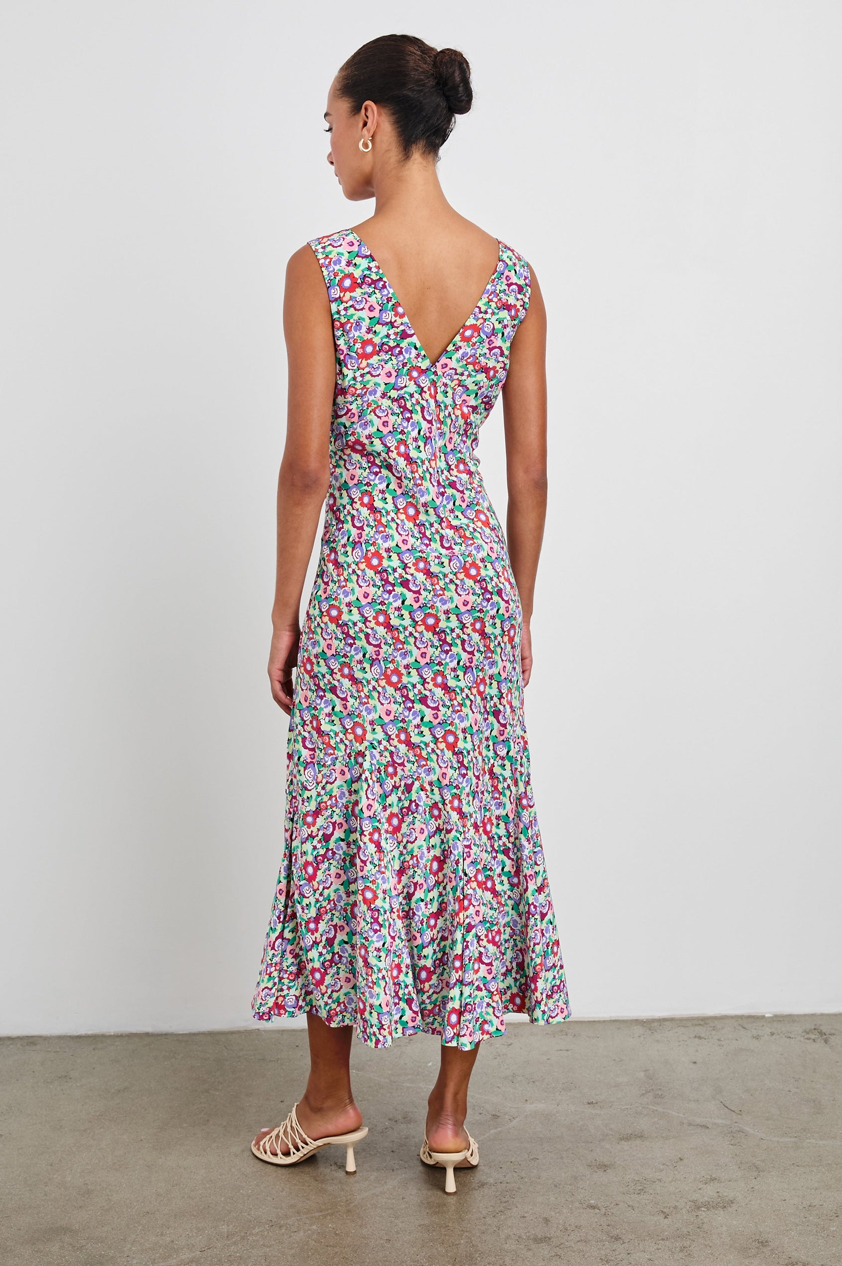 Irra Sleeveless Midi Dress with Wide Shoulder Straps, a Deep V Neck and an Empire Waist in Oversized Multi Floral Colorway, flowers in red, purple, pink and greens - Back Full Body View Featured on Model 