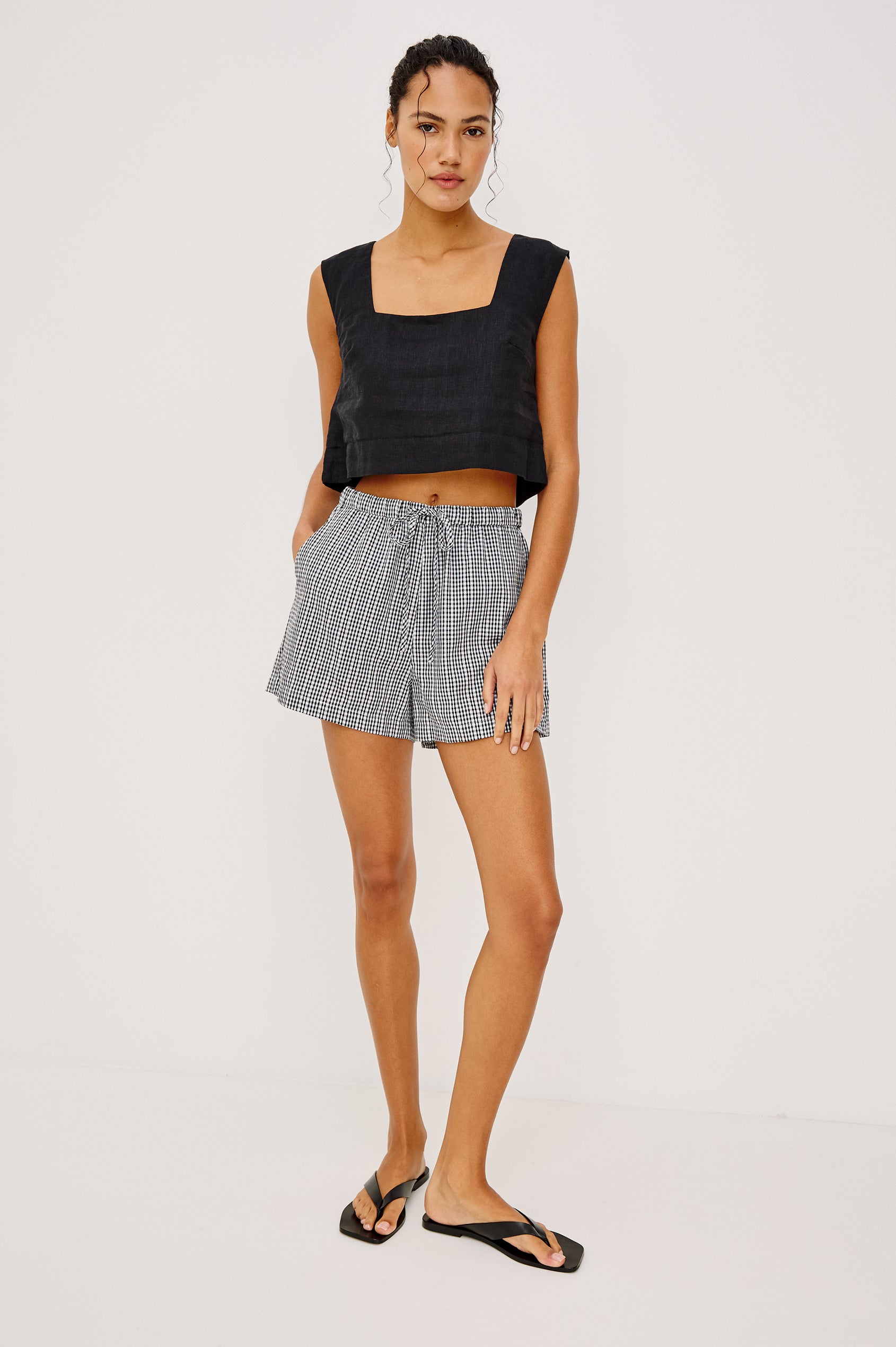 Lizbeth Milkmaid Top in Linen With Floral Eyelet Cutwork Plunging Tie-Front V-Neckline Front Ties Relaxed FIt Short Puff Sleeves in Black Gingham Ctolorway - Full Body Front View Featured on Model
