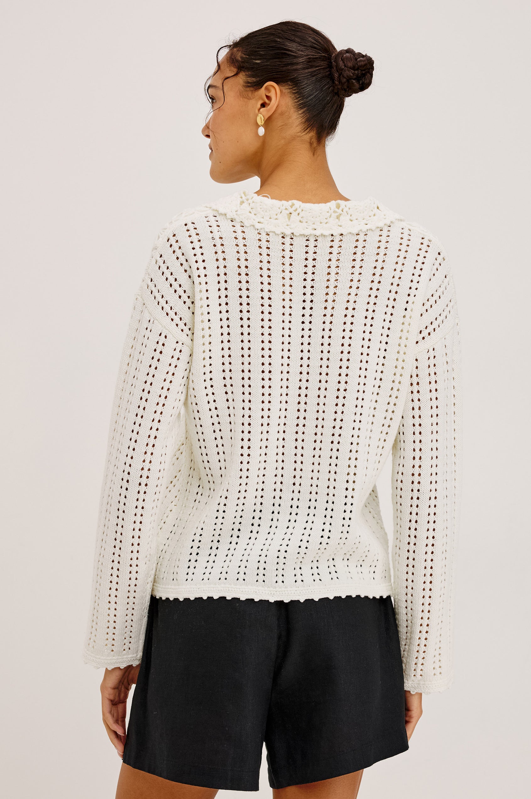 Jenni Cardigan Sweater in Open Weave Cotton Blend Pointelle Knit With Long Sleeves, Crochet Button-Loop Closures, Floral Detailing, and Scalloped Trim in Ivory Colorway - Upper Body Back View Featured on Model