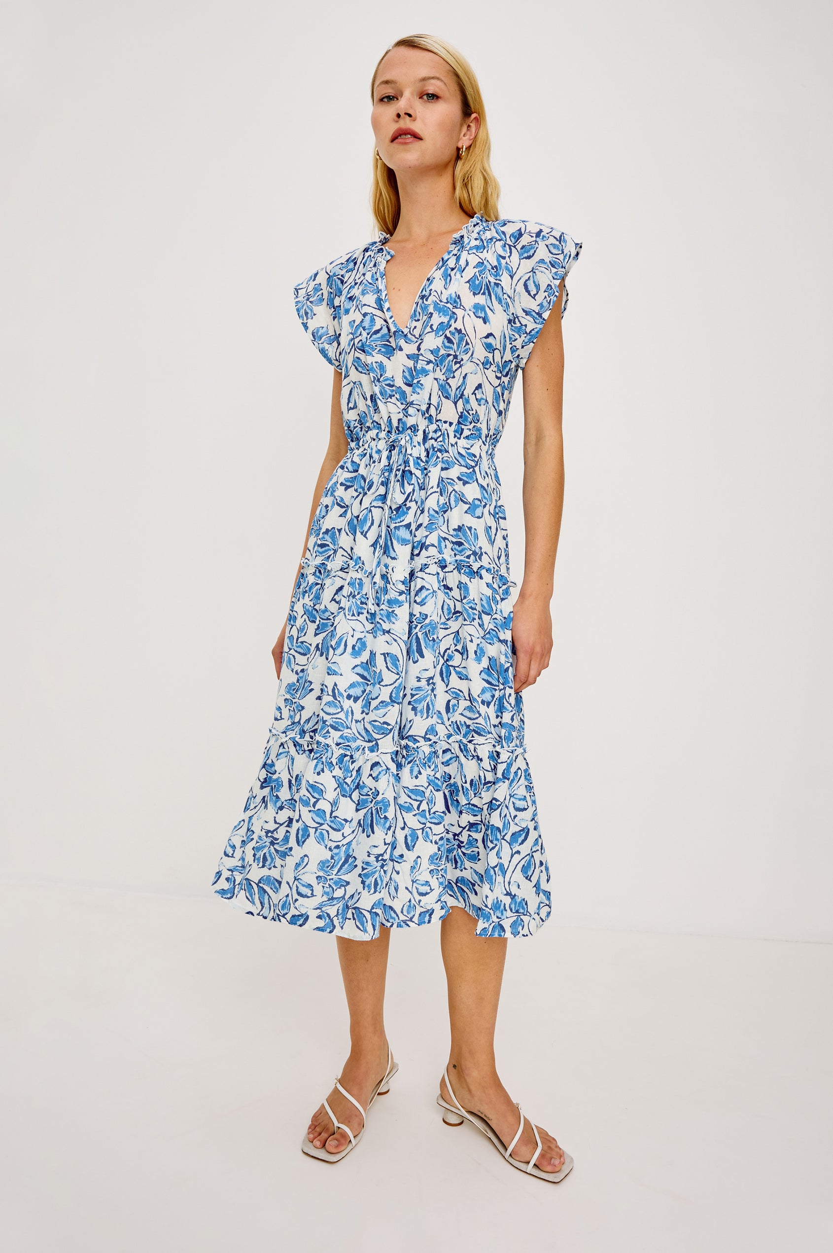 Juni Maxi in Linen With Ruffled Split V-Neckline Flutter Sleeves Adjustable Waist Ties and Fully Lined Tiered Skirt in Azure Jasmine Colorway - Full Body Front View Featured on Model