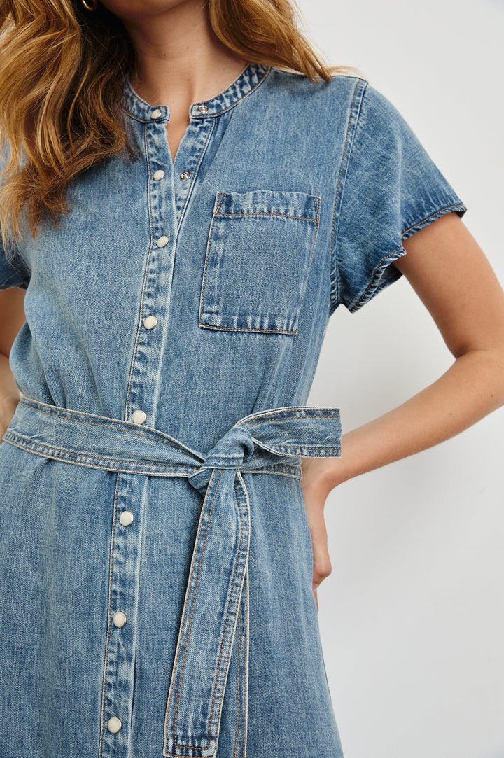 Kahlo Short-Sleeve Midi Dress with Snaps Down the Front, a Waist Tie, a Chest Patch Pocket and a Pleated Hem in Mid Blue Colorway - Front View Featured on Model