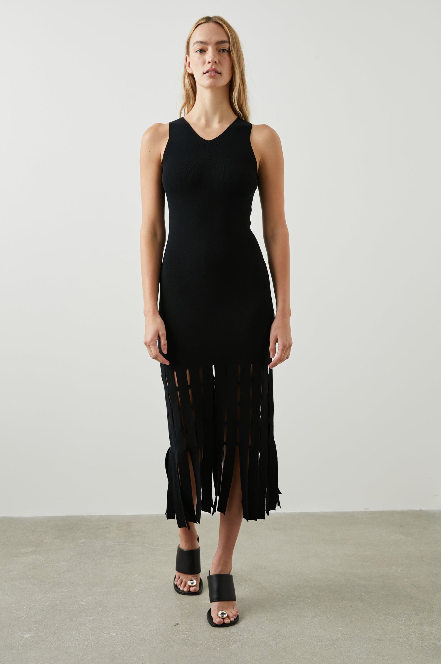 Kaia Sleeveless Midi Dress with a V Neck and Vertical Dashed Cutouts From the Thigh Downward, ending in Panels in Black Colorway - Front Full Body View Featured on Model