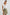 Karysa Short-Sleeve Top with Flutter Sleeves, a Deep V Neck with a Drawstring, Ruching at the Back Collar, and a Vertical Front Center Seam in White Colorway - Front Tucked Full Body View Featured on Model 