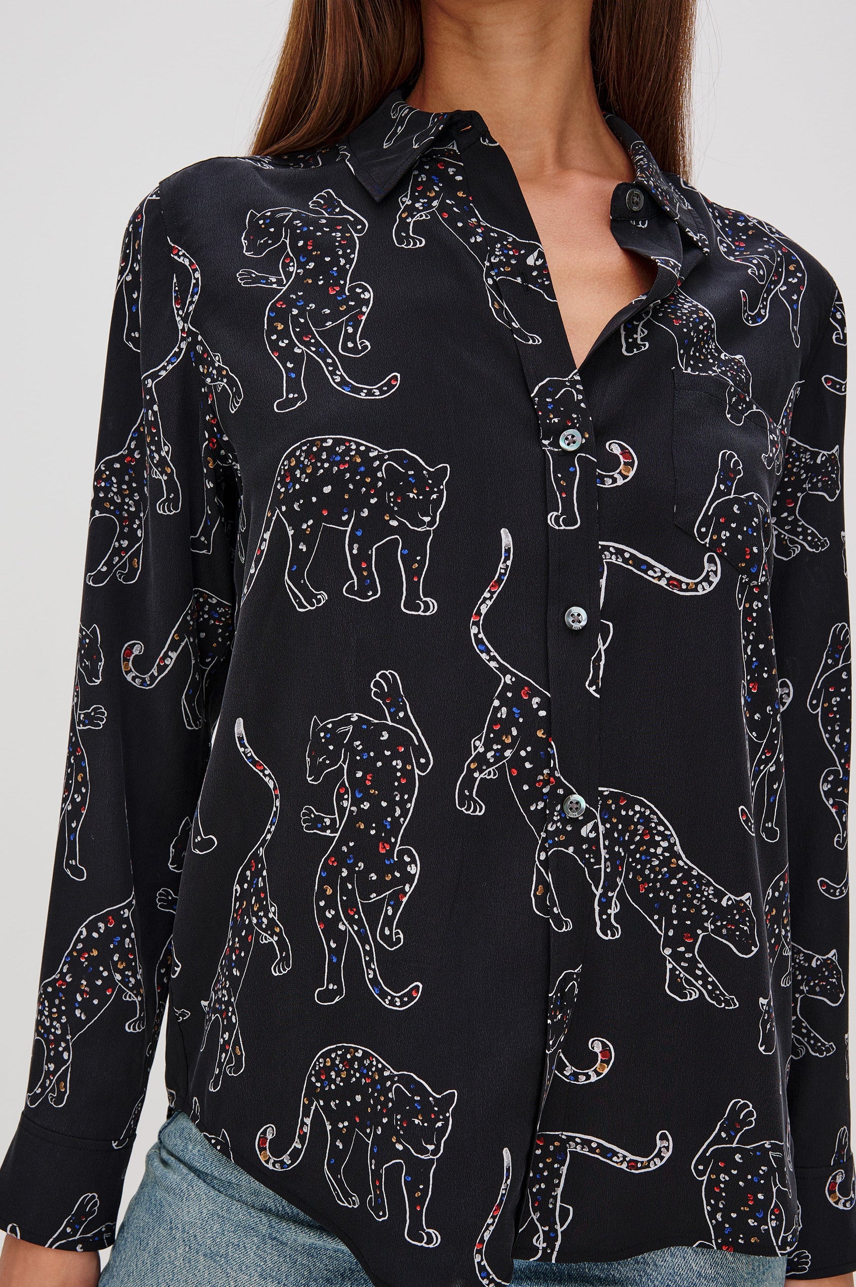 Washed silk button-down shirt in ivory with a horse print. The shirt has a soft drape and classic collar for a polished look. Close Up View on Model.
