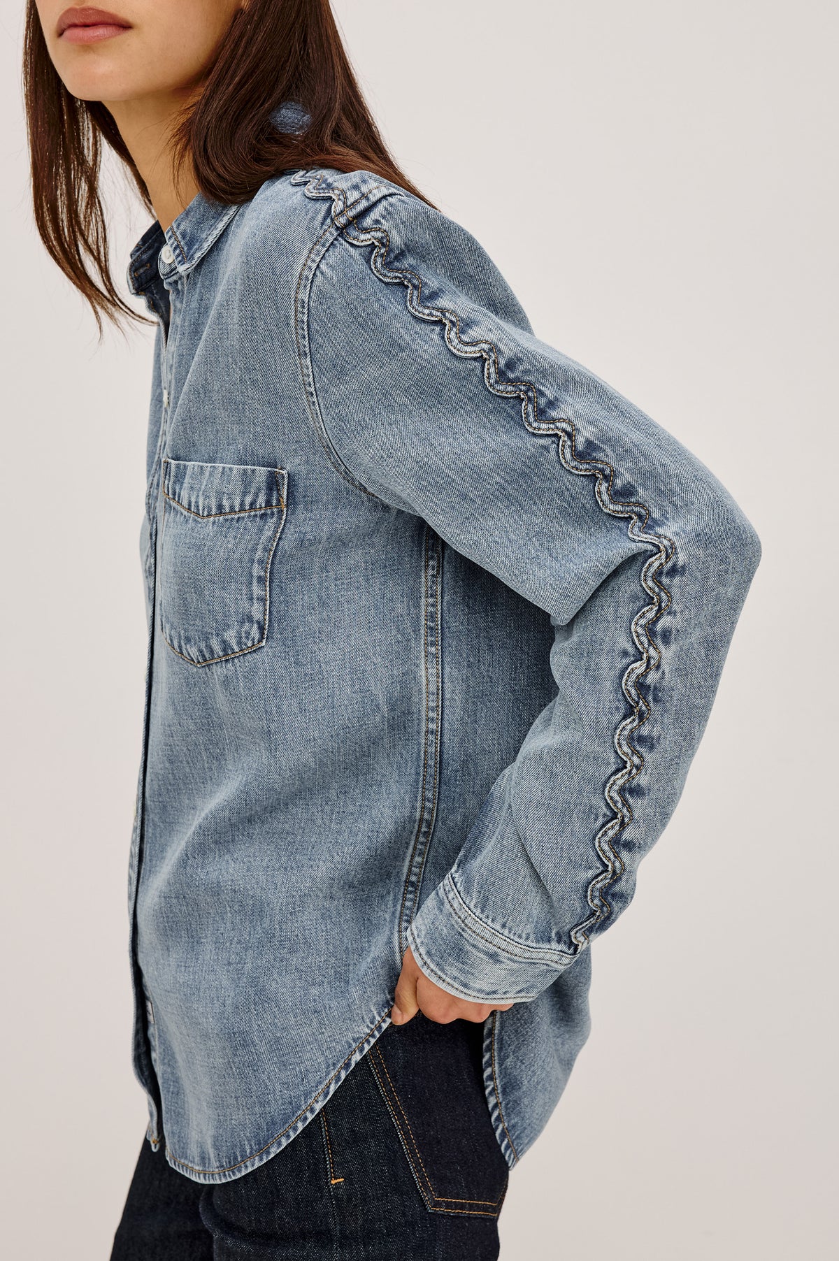 Kellan Shirt in TENCEL™ Denim With Relaxed Fit, Chest Patch Pocket, Zig-Zag Trim at Long Sleeves, Front Buttons, and Shirttail Hem in Mid Blue Colorway - Upper Body Front Detail View Featured on Model.