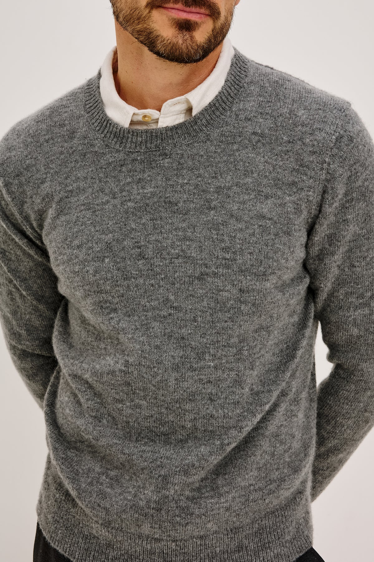 Laurent Sweater in Wool Blend With Crewneck, Dropped Shoulders, Linked Stitch Detailing, and Long Sleeves in Charcoal Colorway - Upper Body Front Close Up View Featured on Model
