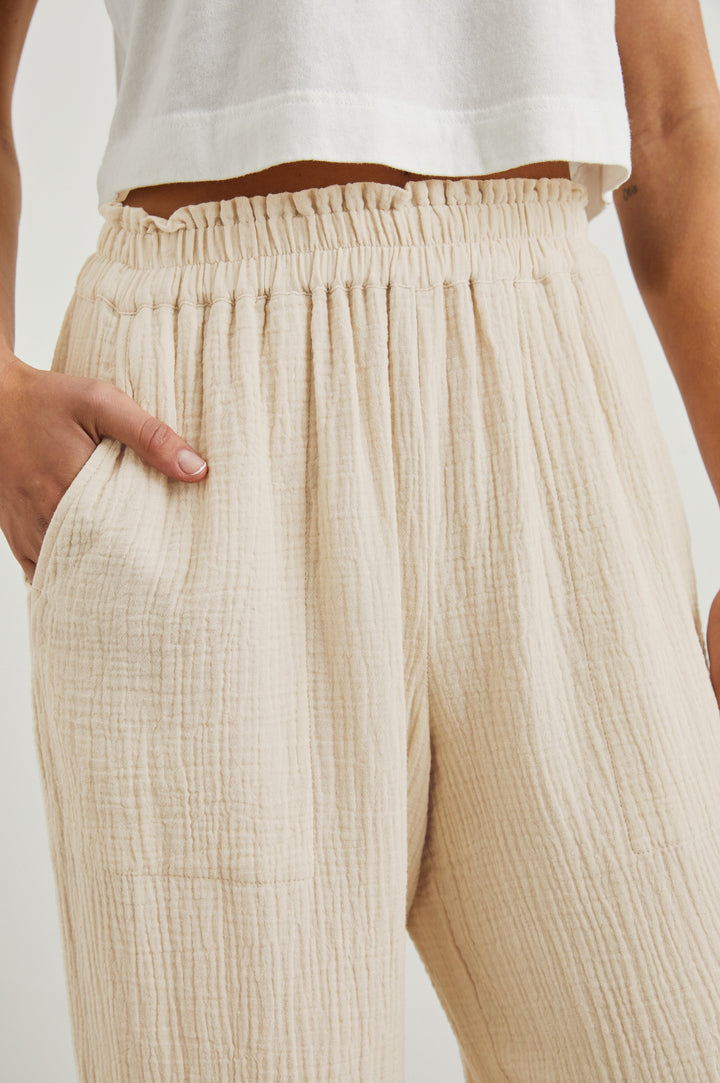 Leon Crop Pant with a Smocked Waistband and Two Front Seam Pockets in Flax Colorway - Front View Featured on Model
