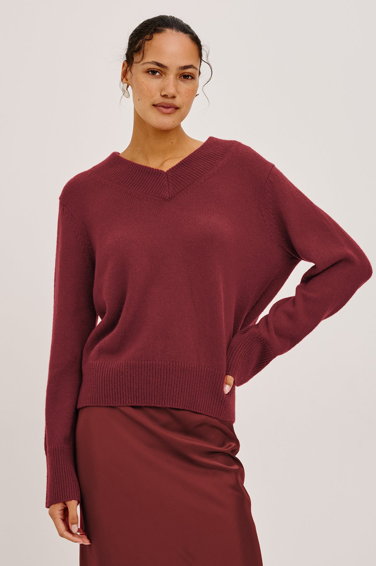 Lidya Sweater in Wool-Cashmere Knit Blend With V-Neckline, Loose Relaxed Fit, Long Sleeves, and Ribbed Trim in Crimson Colorway - Upper Body Front View Featured on Model