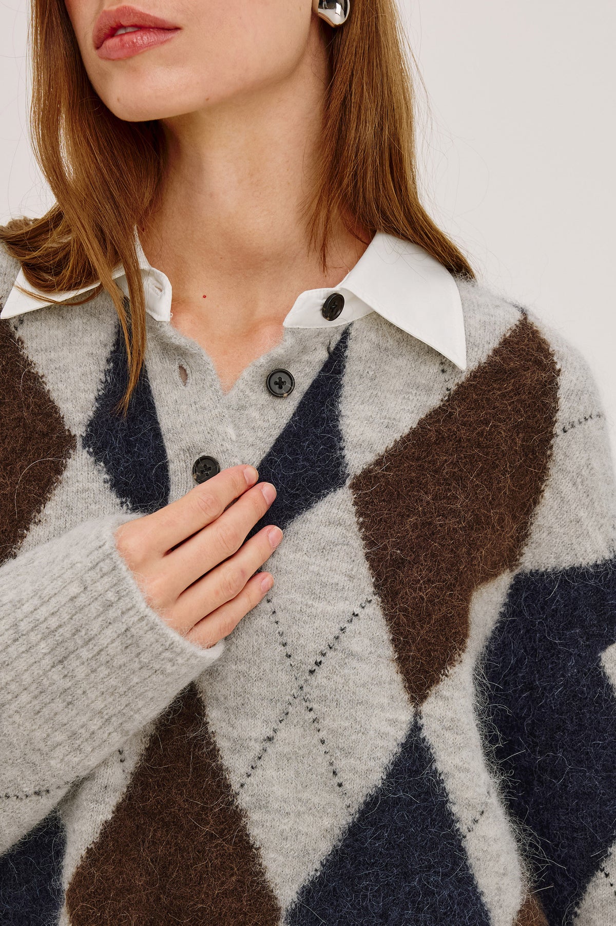 Linda Sweater in Alpaca Blend Knit With Contrast Polo Collar and Button Placket, Slightly Oversized Relaxed Fit, and Ribbed Trim in Cedar Argyle Colorway - Upper Body Front Detail View Featured on Model.