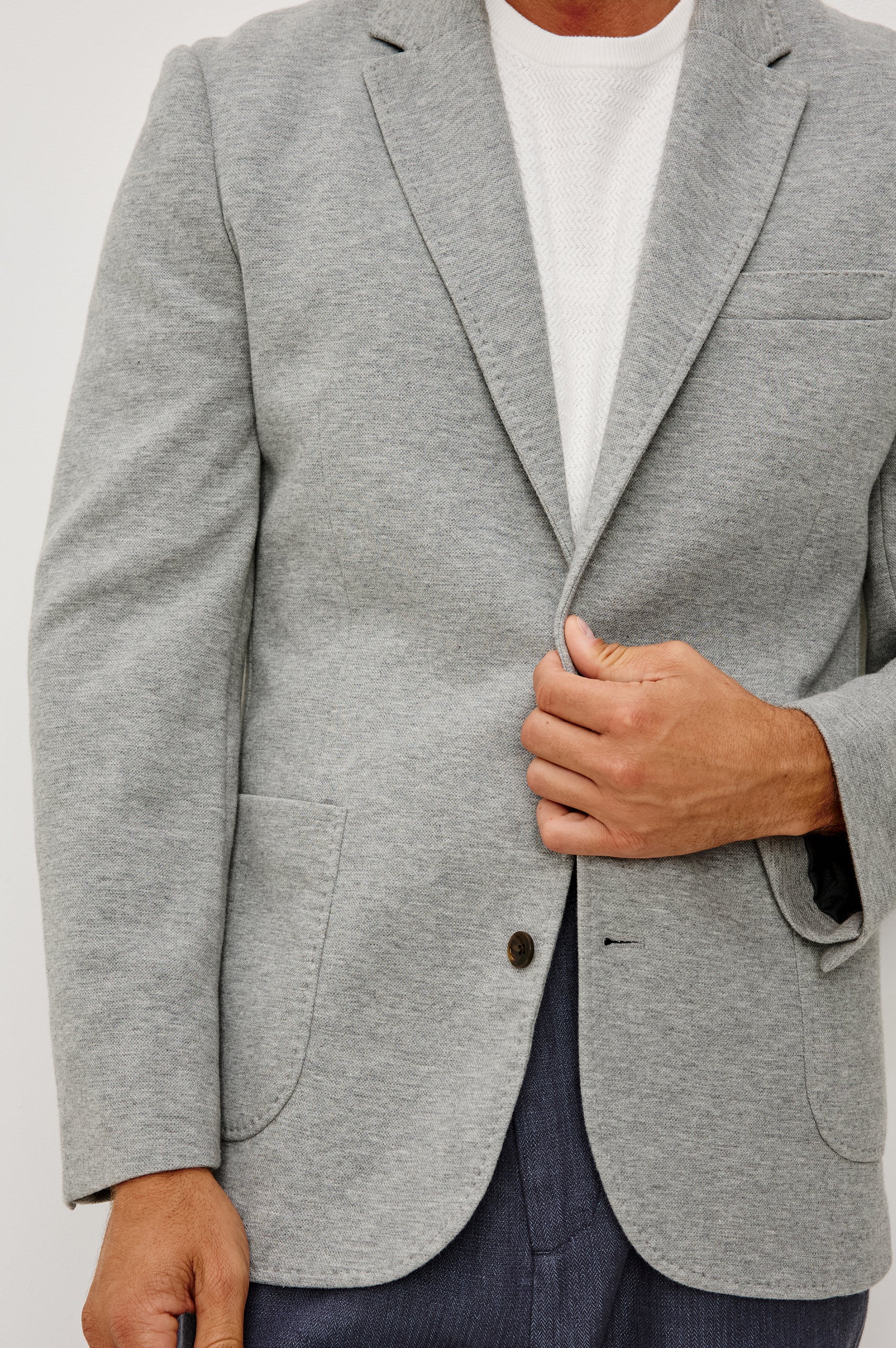 Lorenz Blazer in Cotton Blend With Notched Lapels, Long Sleeves, Front Buttons, Chest Pocket, and SIde Patch Pockets in Heather Grey Colorway - Upper Body Close Up View Featured on Model