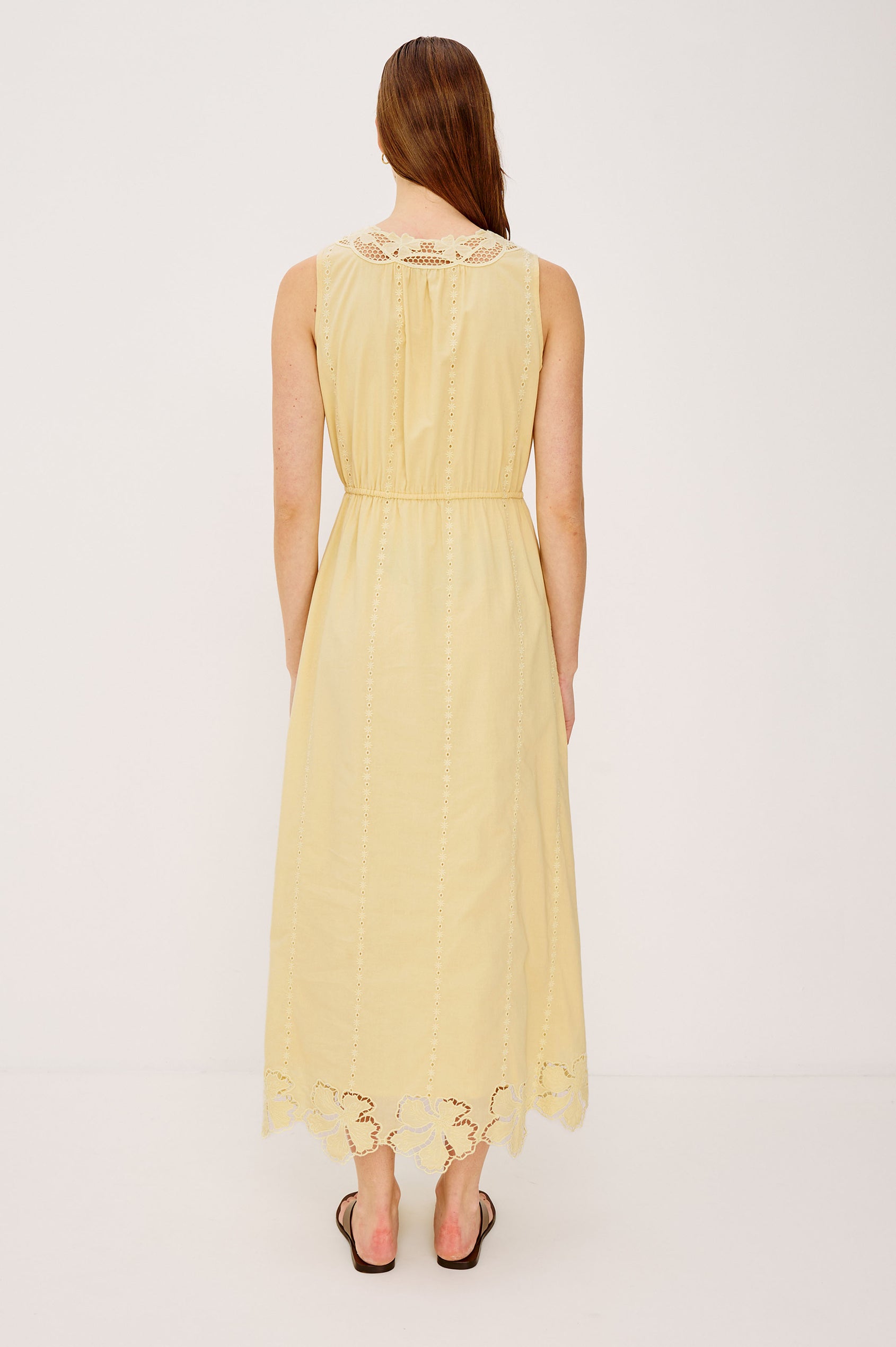 Lorina Midi Dress in Beach Cottton With Lattiice and Floral Embroidery, Sleeveless Cut, and Adjustable Waist Ties in Sunshine Colorway - Full Body Back View Featured on Model