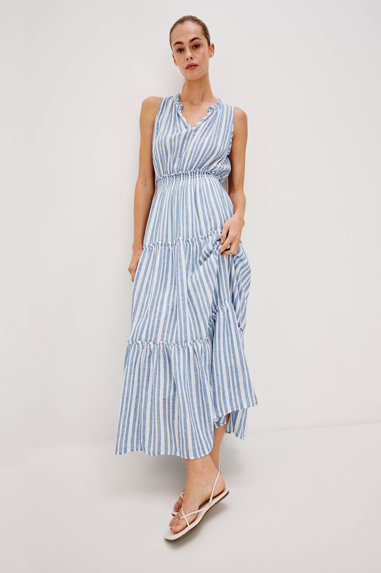 Loulou V-Neck Midi Dress with Smocked Elastic Waistband and a Multi Tiered Skirt in Blue/White Jalisco Stripe Colorway. Full Body Front View Shown on Model.