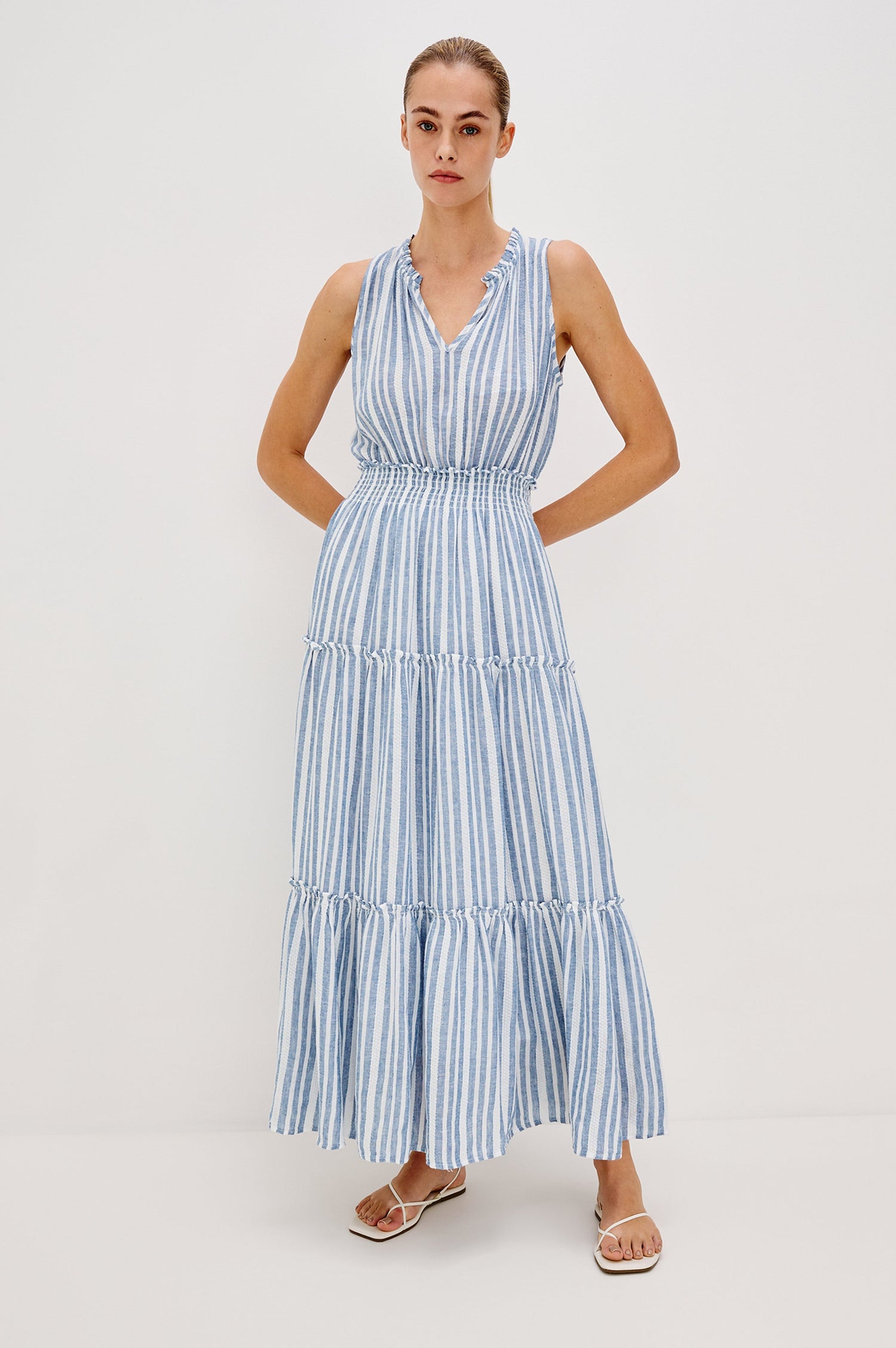 Loulou V-Neck Midi Dress with Smocked Elastic Waistband and a Multi Tiered Skirt in Blue/White Jalisco Stripe Colorway. Full Body Front View Shown on Model.