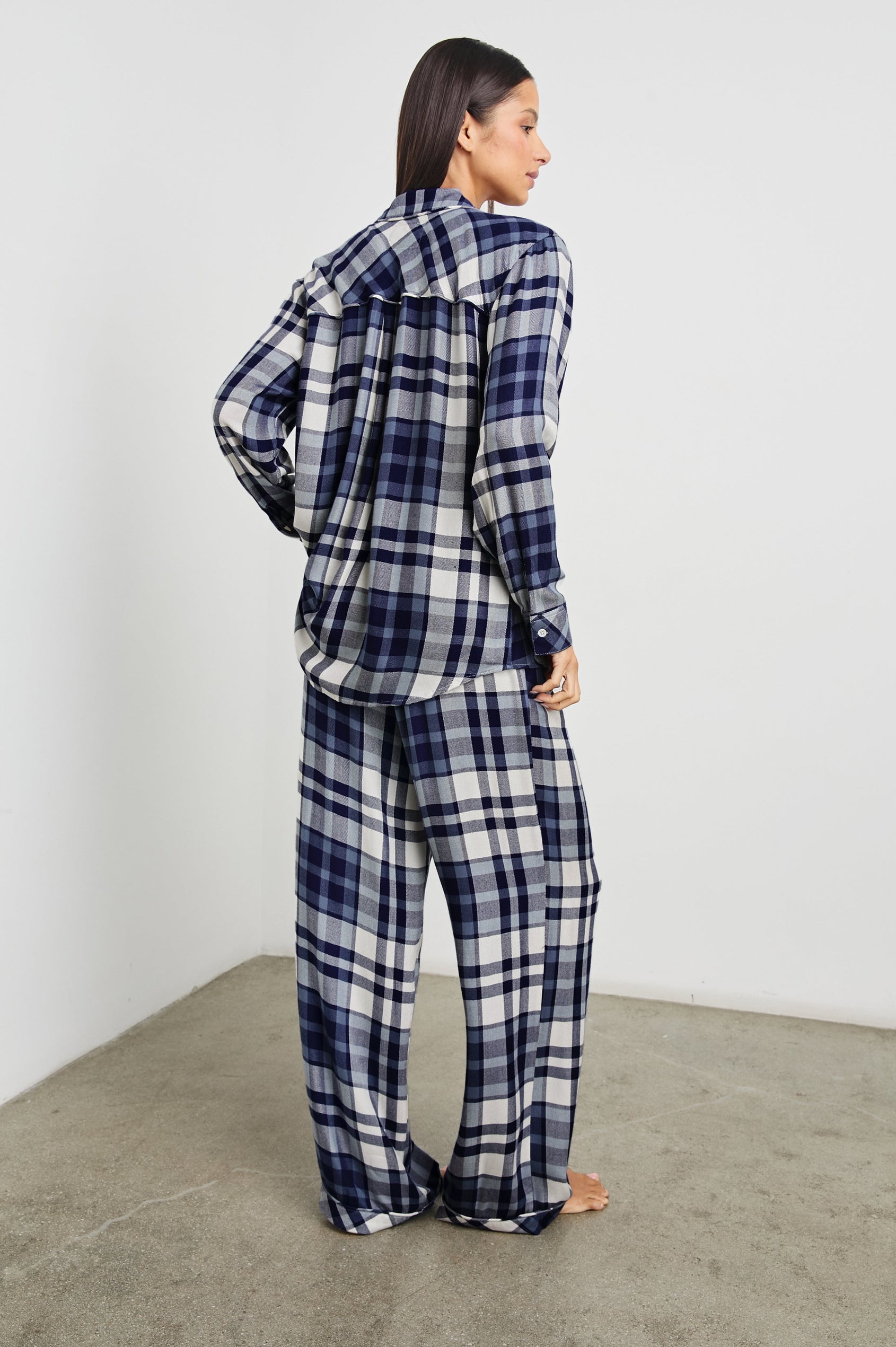 Luna Pajama Set with a Long Sleeve, Button Up, V Neck Top with a Chest Patch Pocket and Pants with Two Front Pockets in Lake Blue Cloud Colorway, a plaid - Back Full Body View Featured on Model  