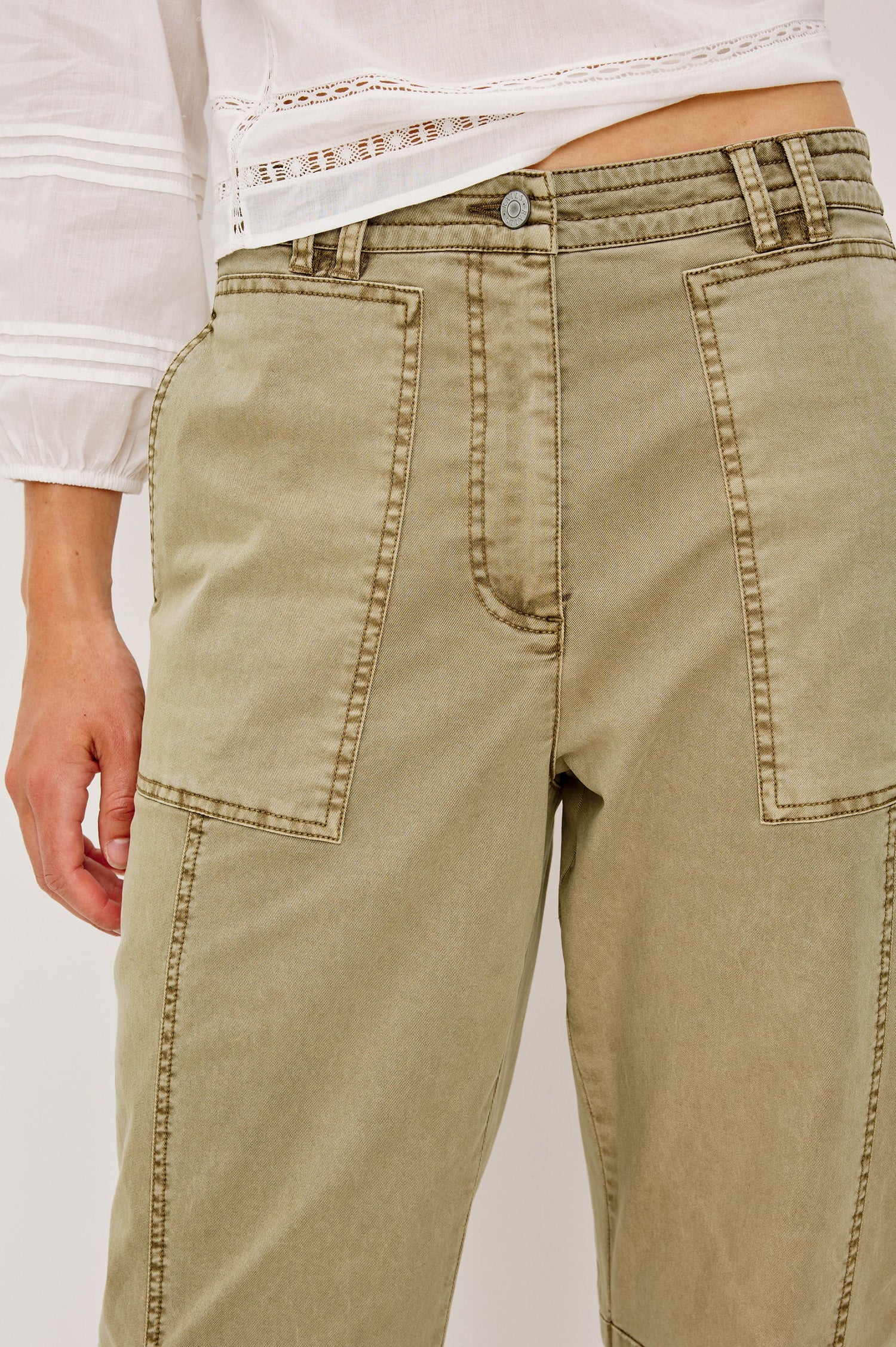 Mid-rise, barrel-leg pants made from stretch twill in Light Olive colorway. The pants have knee seaming, front pockets, a zip fly, and an adjustable drawstring waist for a casual, comfortable fit. Close up of details on model.